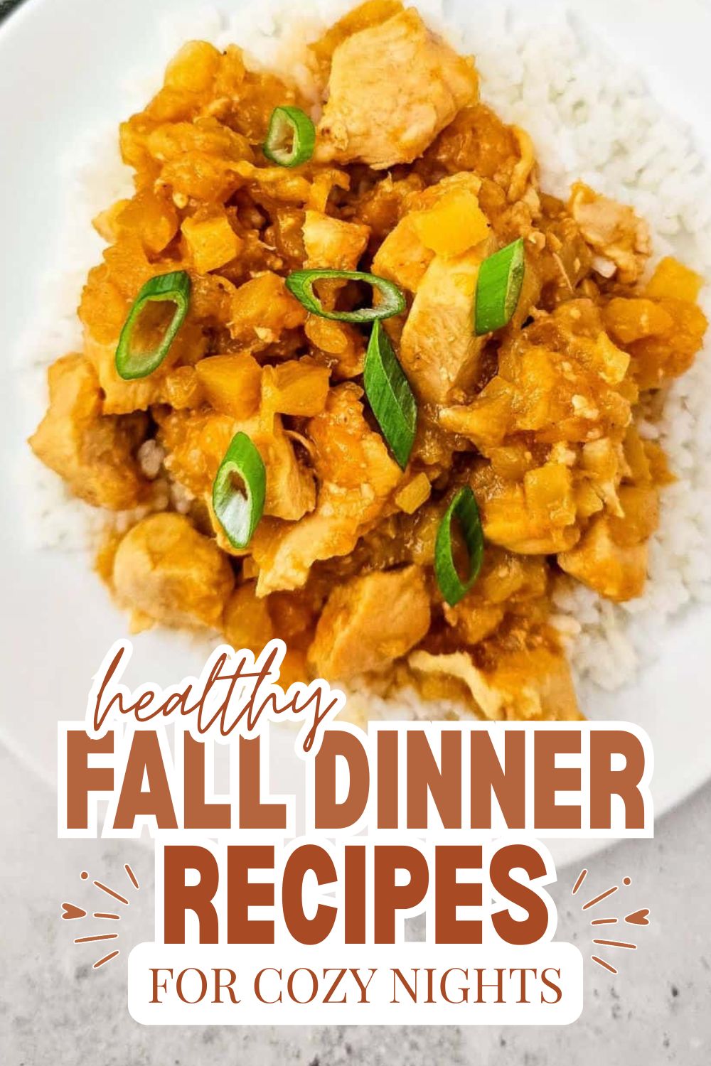 Vegetarian pumpkin curry served over rice with green onions on top.