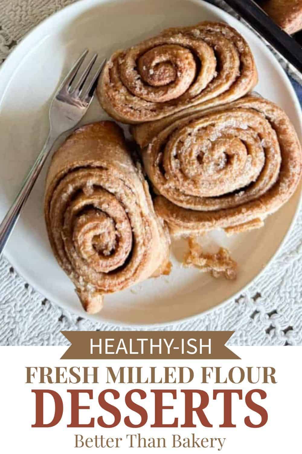 Freshly baked cinnamon rolls made with fresh milled flour on a white plate.
