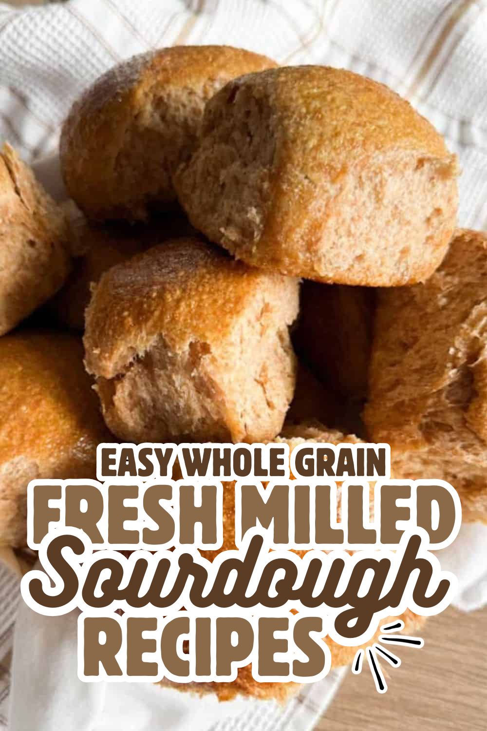 Freshly baked whole grain sourdough bread rolls on a wooden surface.
