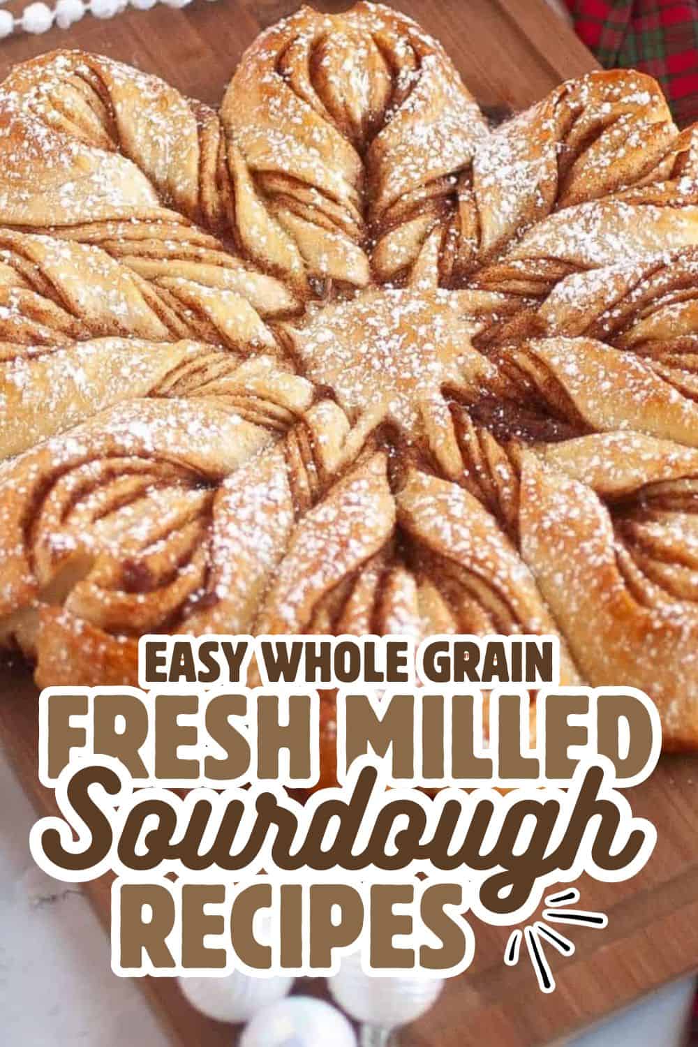 Freshly baked sourdough bread with a twisted, golden crust, dusted with flour, on a wooden surface.