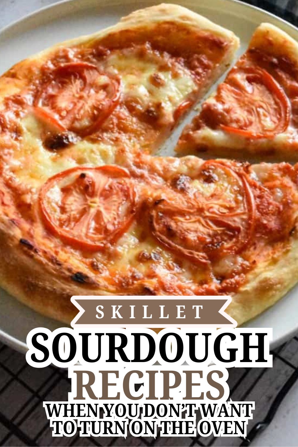 Delicious skillet sourdough bread topped with tomatoes and melted cheese.