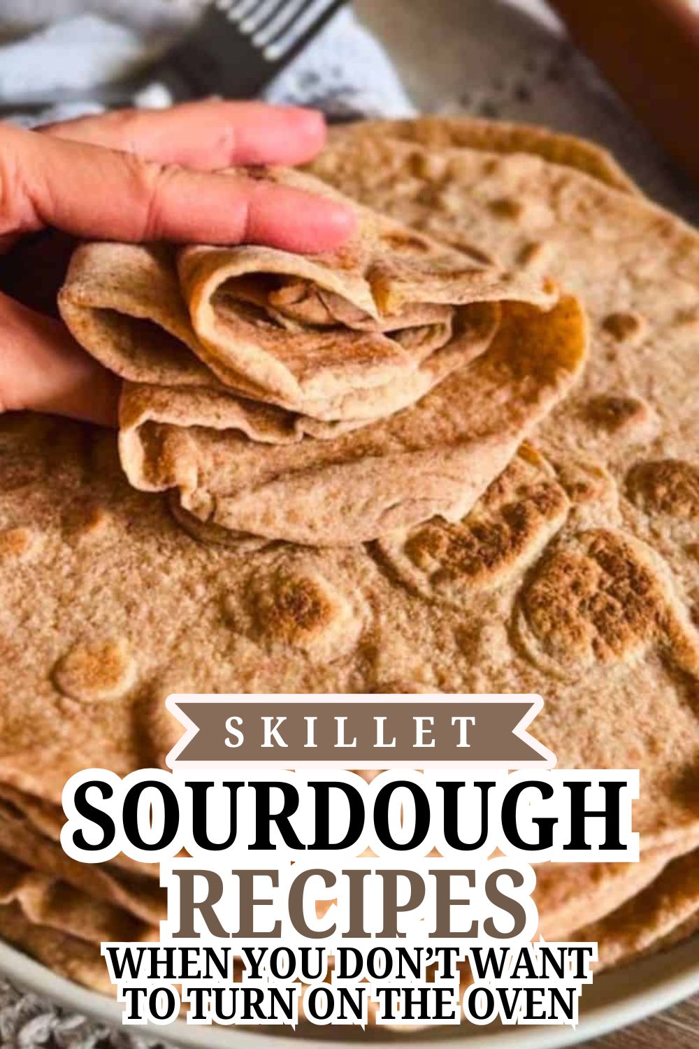Close-up of hand holding a piece of freshly baked sourdough bread.