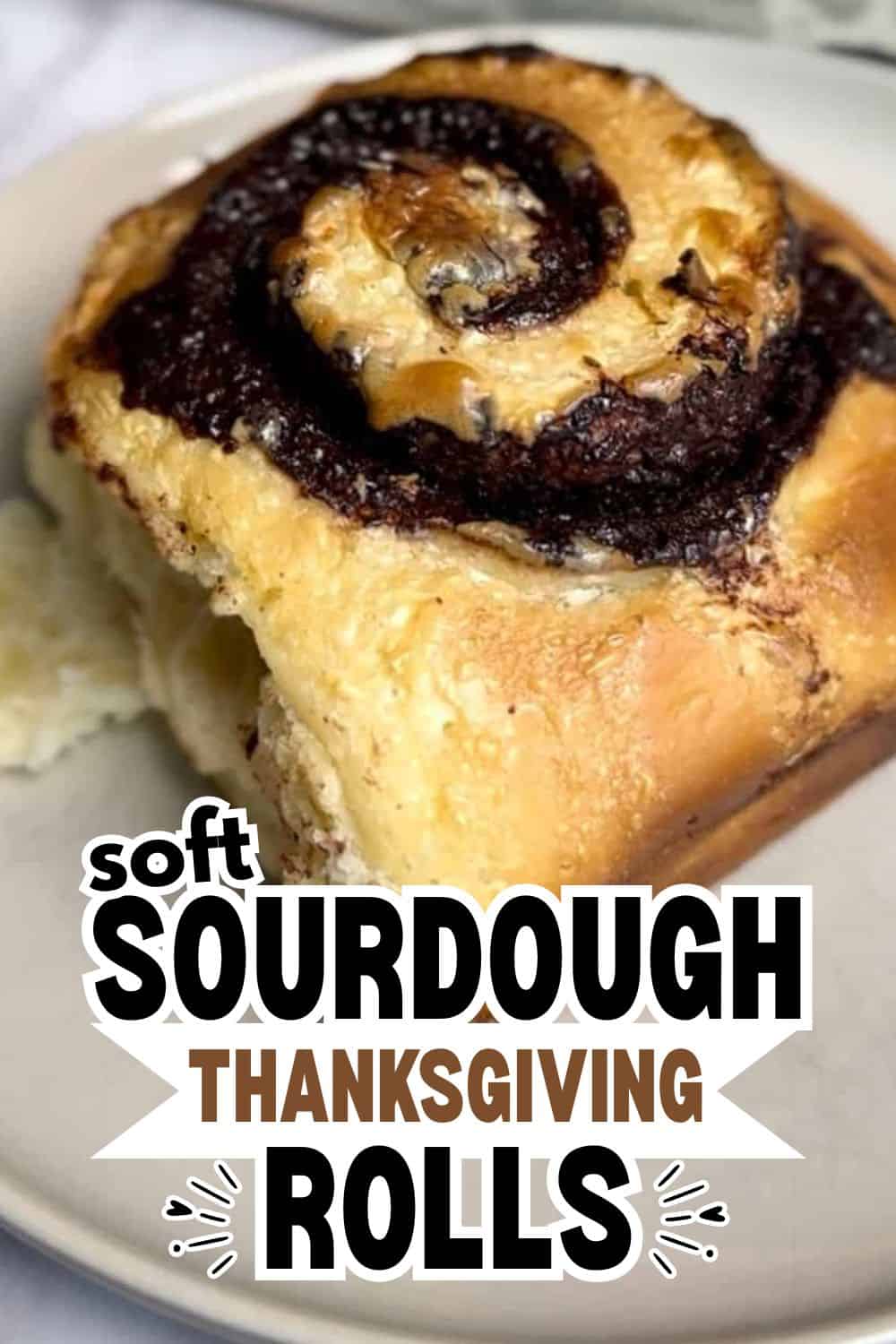 Close-up of a freshly baked sourdough roll with a swirl of chocolate or cinnamon filling.