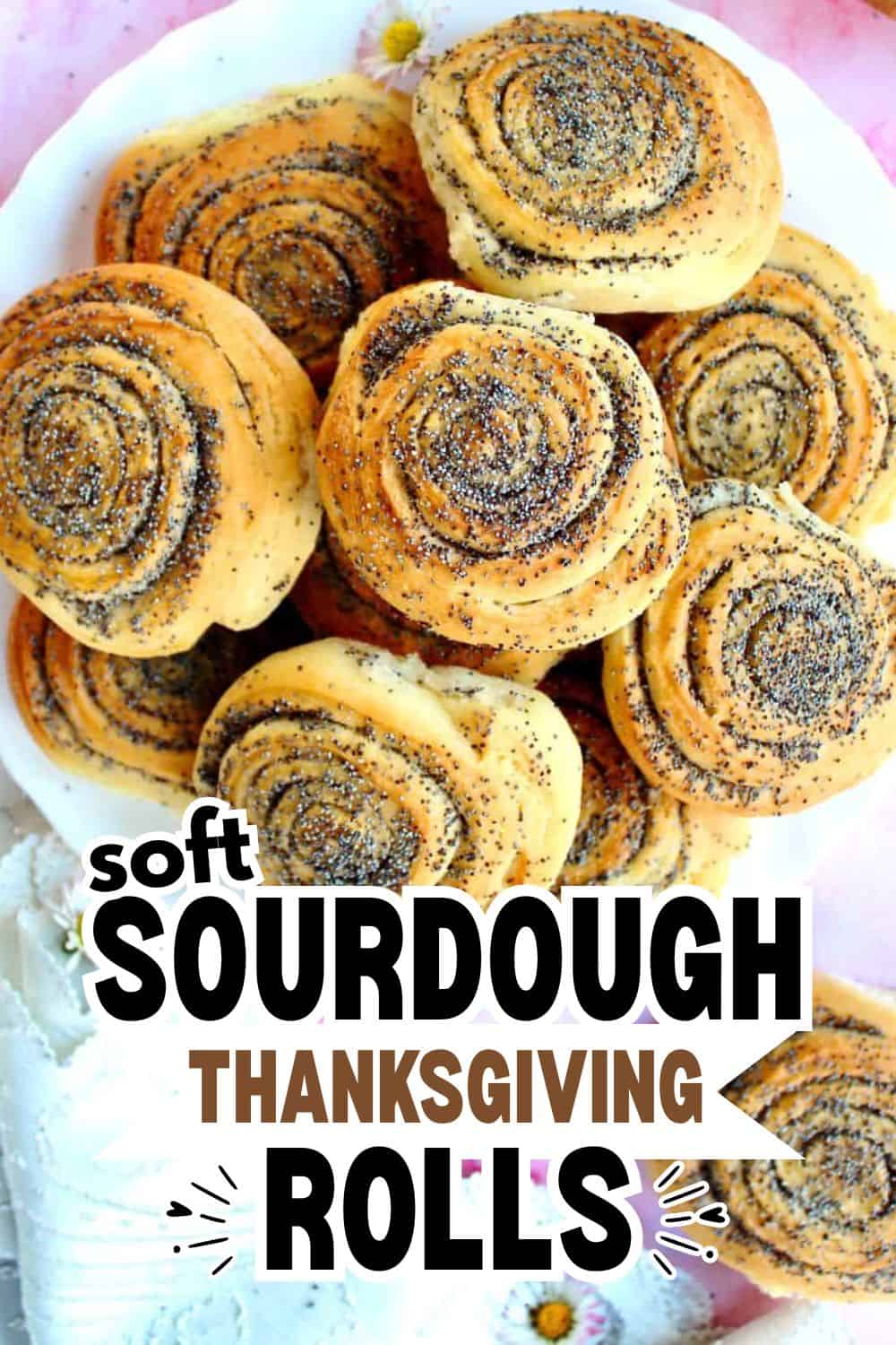 Freshly baked sourdough rolls with swirl pattern and poppy seeds on top.