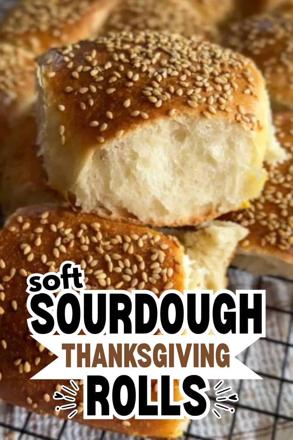 Close-up of soft sourdough rolls topped with sesame seeds.