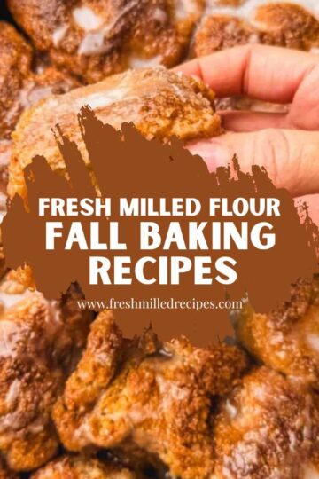 Close-up of hand holding a baked treat with fresh milled flour in background.