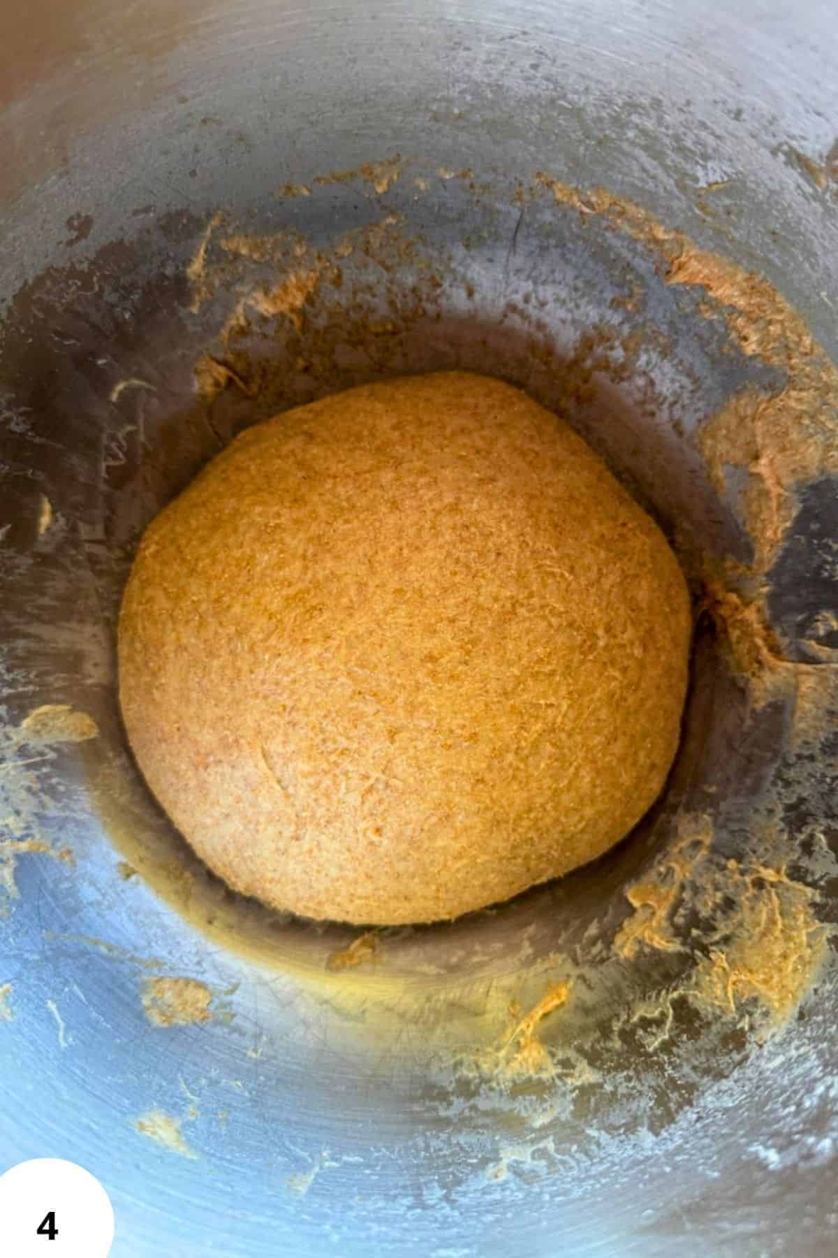 Dough ball in mixing bowl ready for baking or filling.