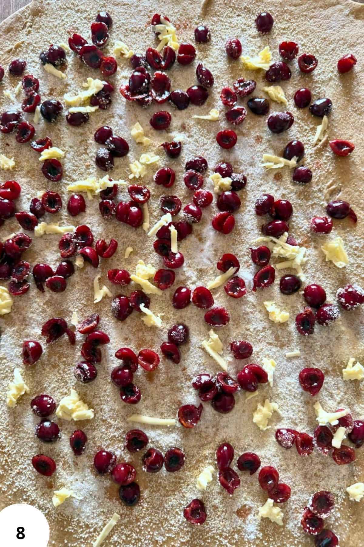 Close-up of cherry and white chocolate topping on pastry dough.