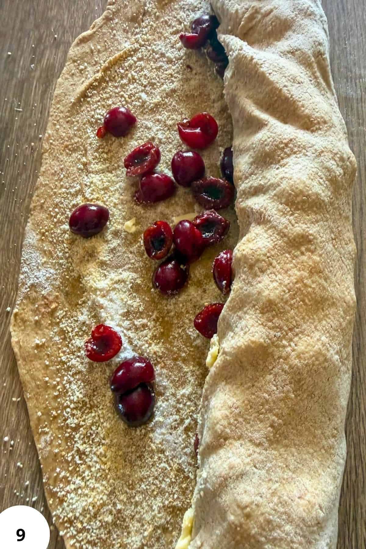 Cherry strudel with fresh cherries and powdered sugar on top.