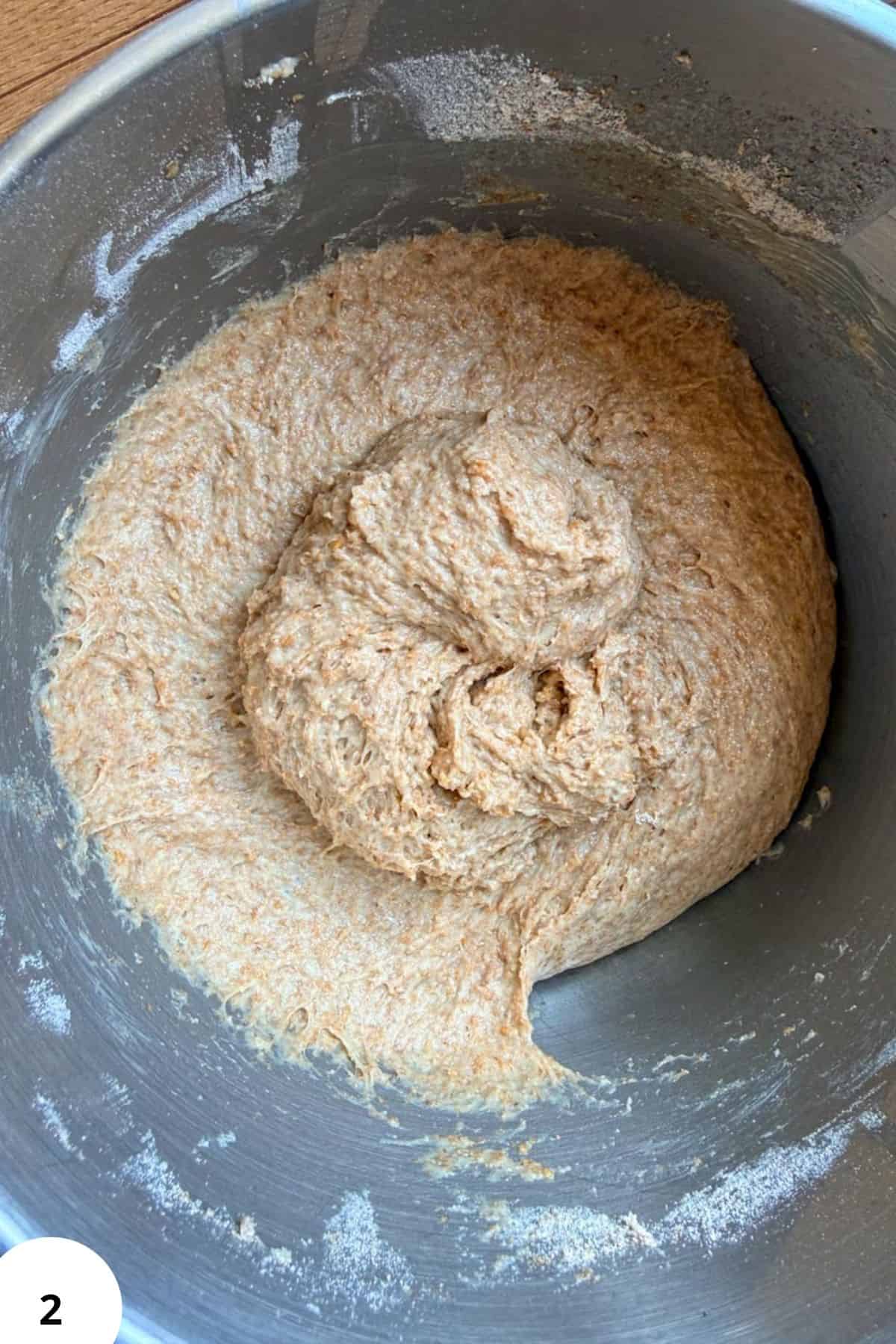 Sourdough dough in a mixing bowl with flour and starter.