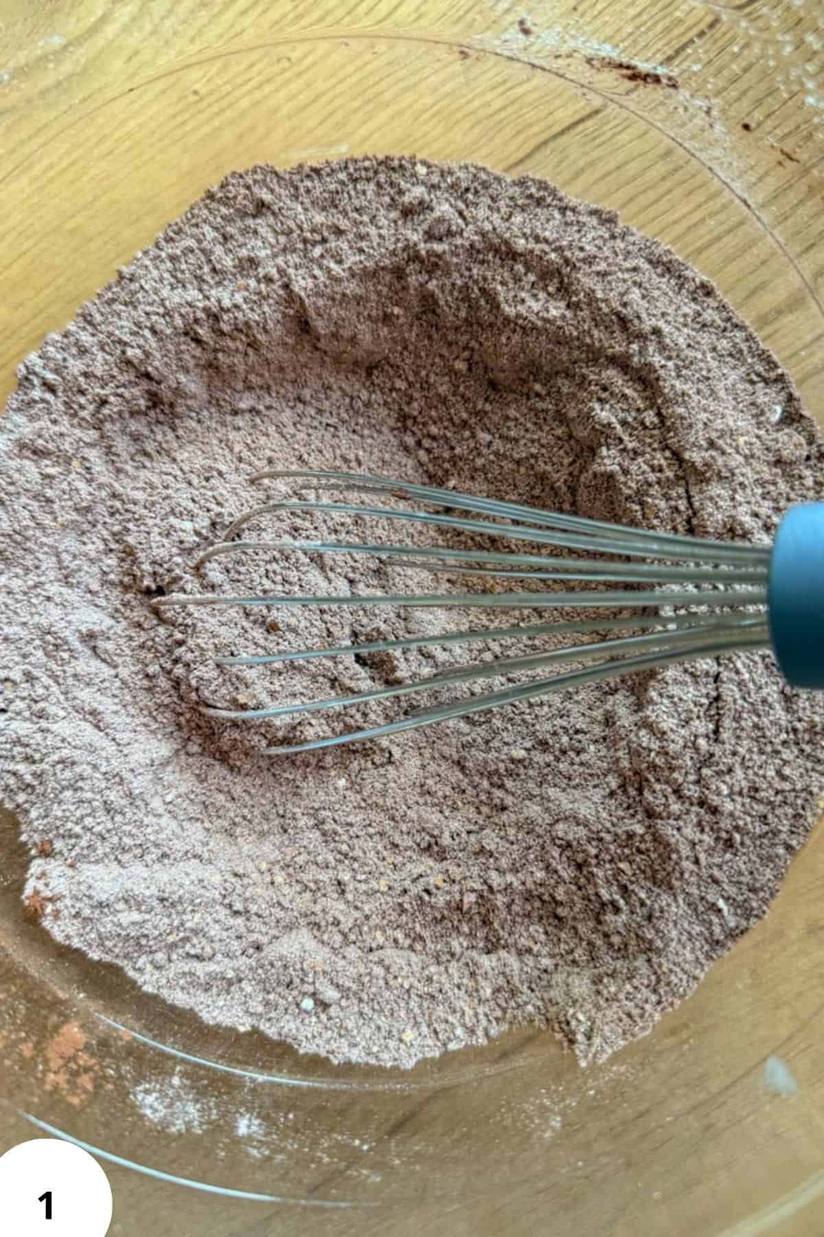 Mixing freshly milled flour in a glass bowl for zucchini muffins.