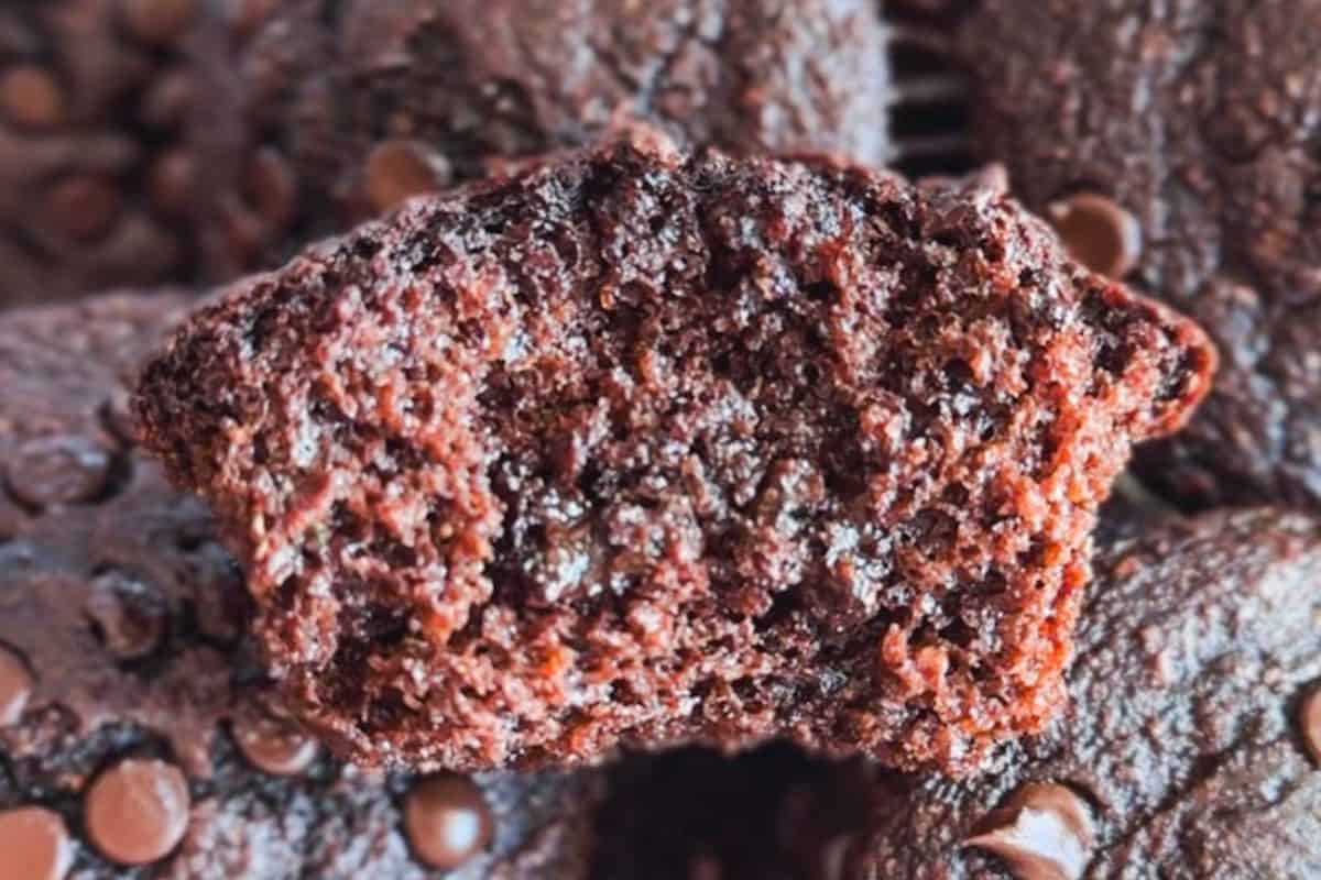 Close-up of a moist, chocolate zucchini muffin with sugar topping.