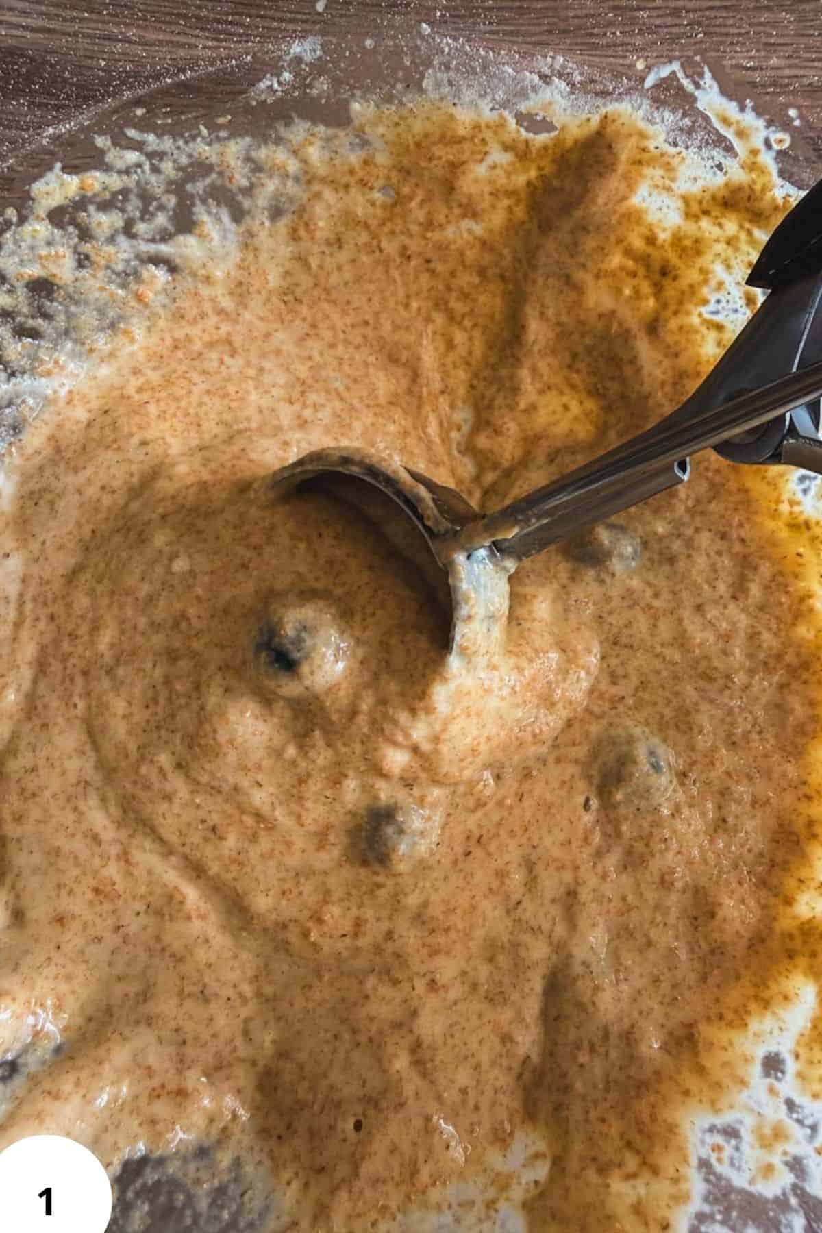 Mixing sourdough pancake batter with a hand mixer in a bowl.