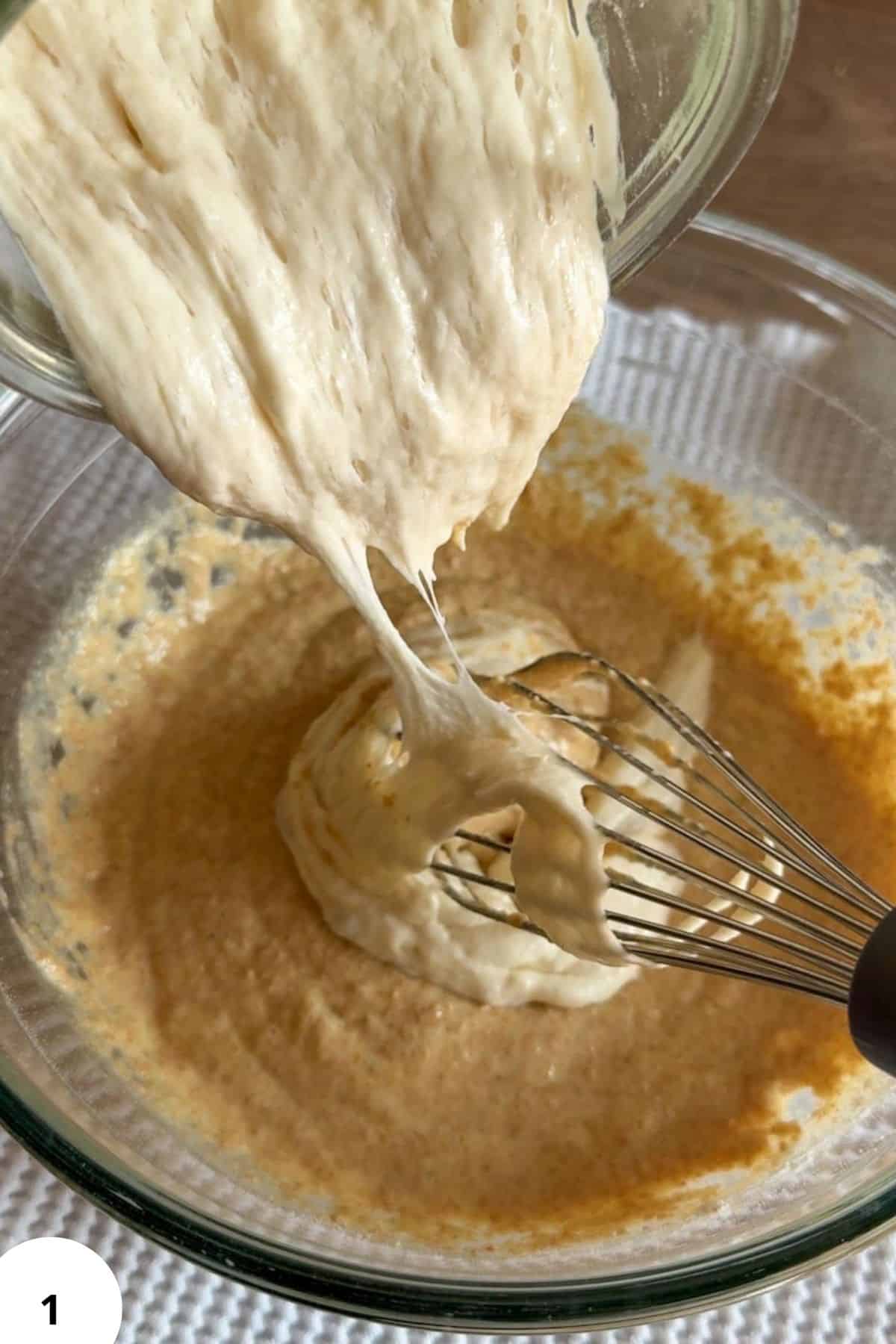Mixing fresh milled sourdough pancake batter with a whisk in a glass bowl.