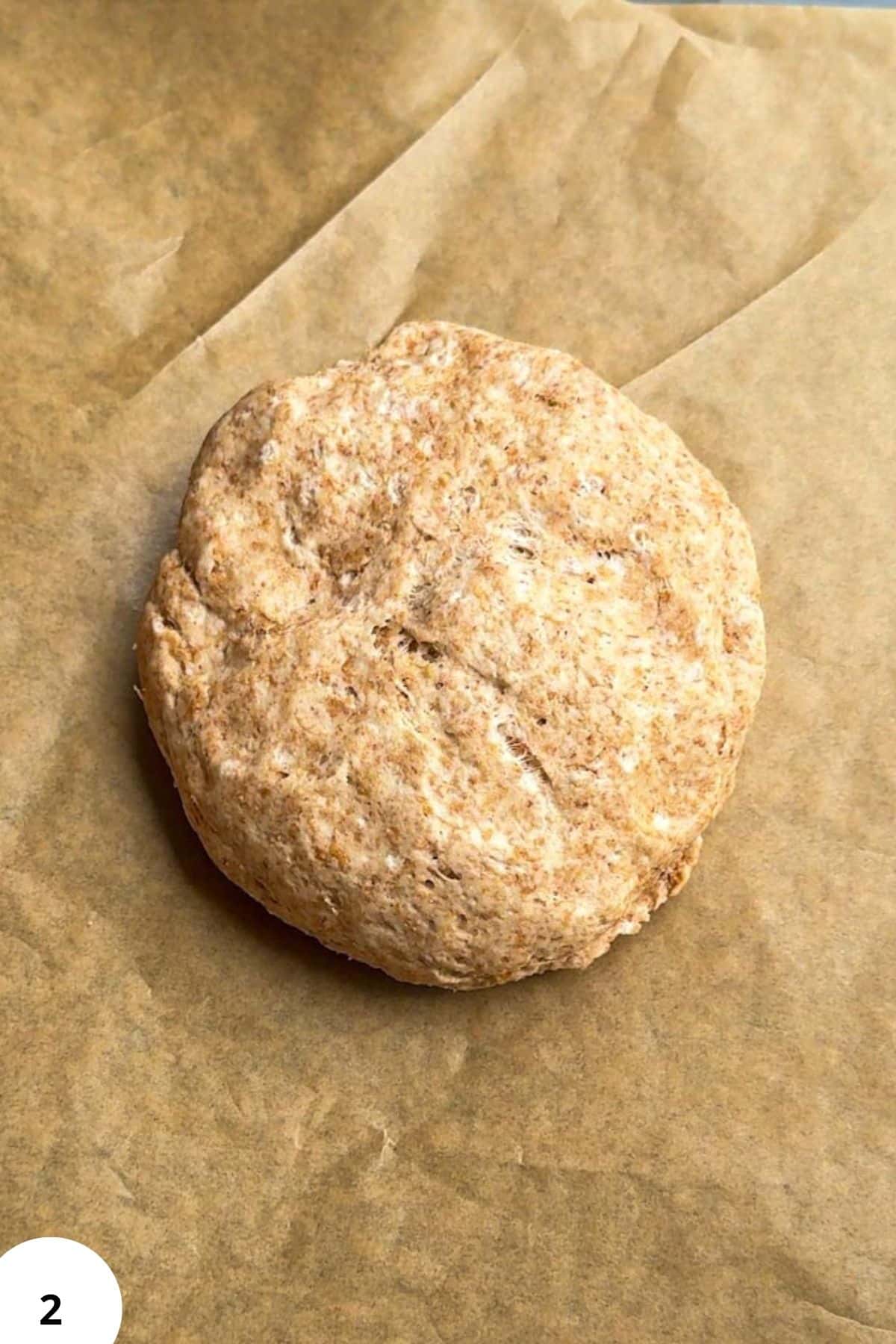 Freshly baked sourdough seed cracker on parchment paper.