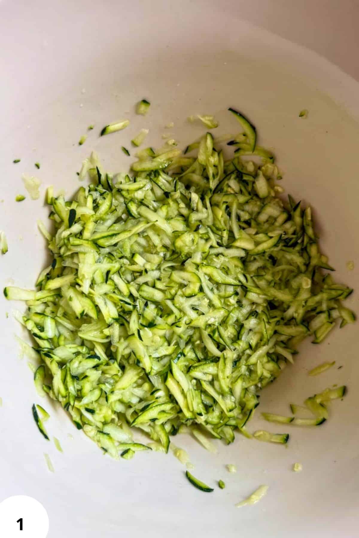 Chopped fresh zucchini in a bowl for zucchini fritters.