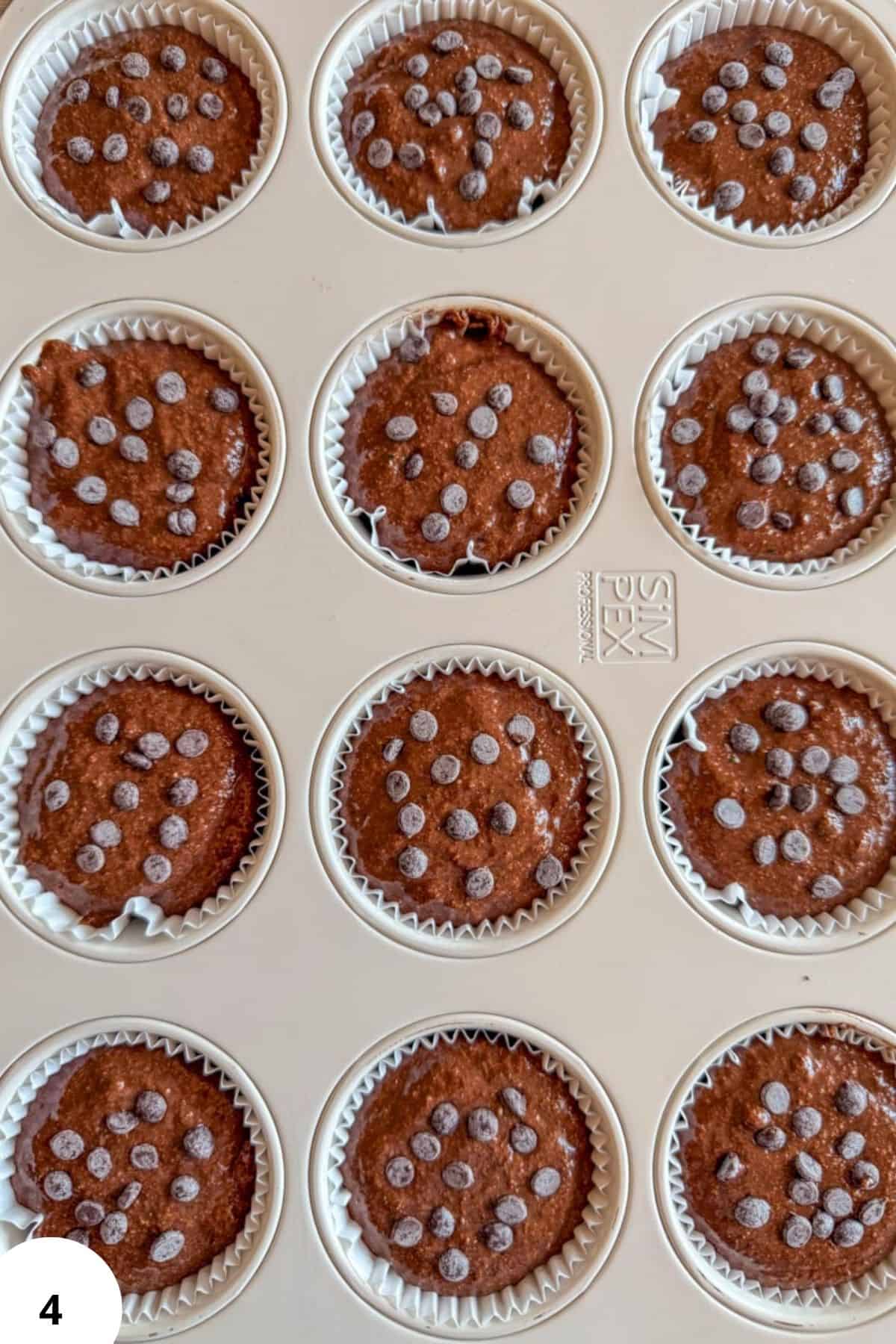 Chocolate zucchini muffins with sugar crystals in paper liners.