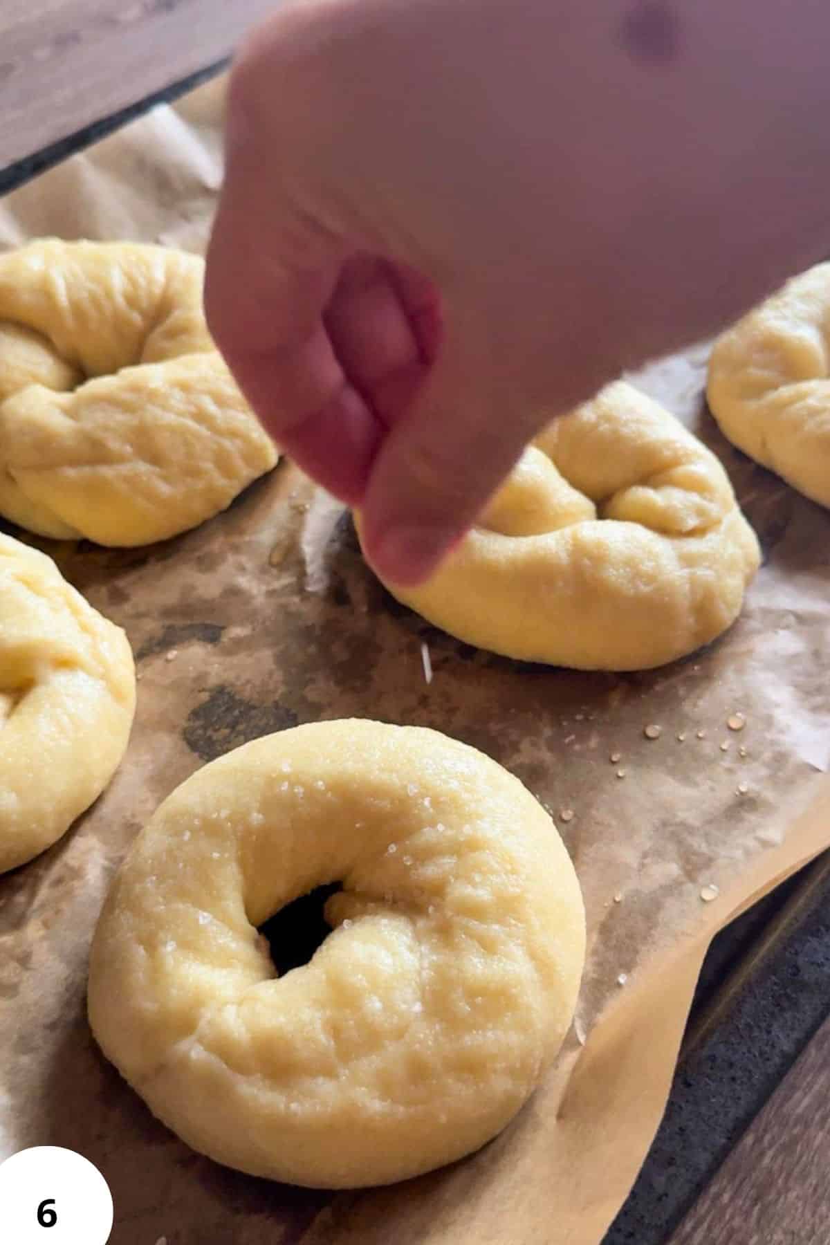 Hand shaping bagels during the stretch and fold process for bread baking.