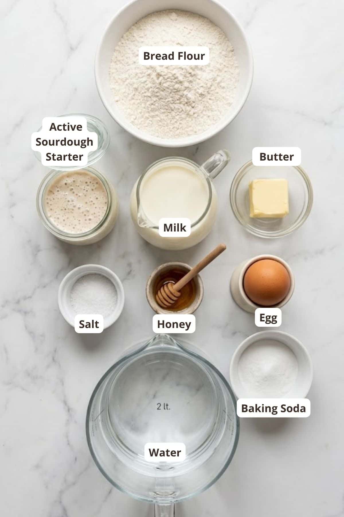Ingredients for bread dough including flour, sourdough starter, milk, butter, egg, salt, honey, andb.