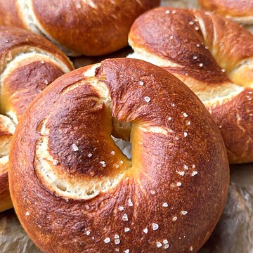 Close-up of golden-brown bagels with salt crystals on top.