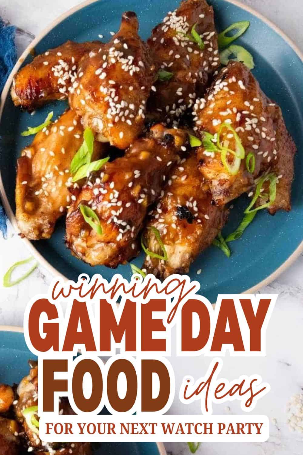 Delicious glazed chicken wings with sesame seeds and green onions on a blue plate.