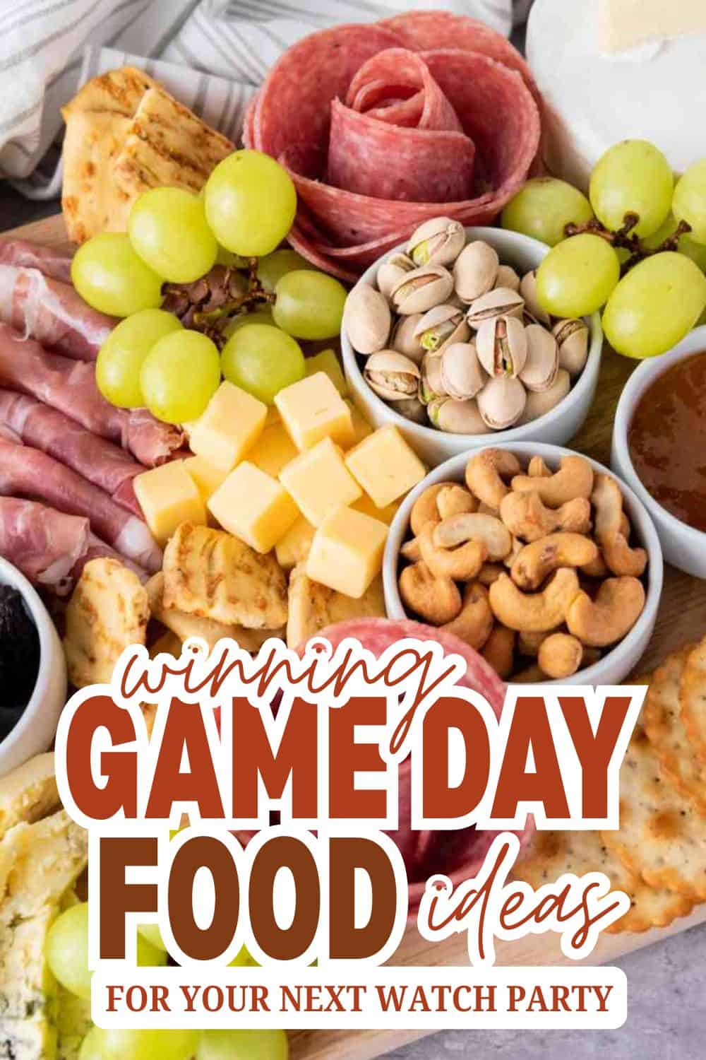 Variety of snacks including cheese, grapes, nuts, and meats for game day.