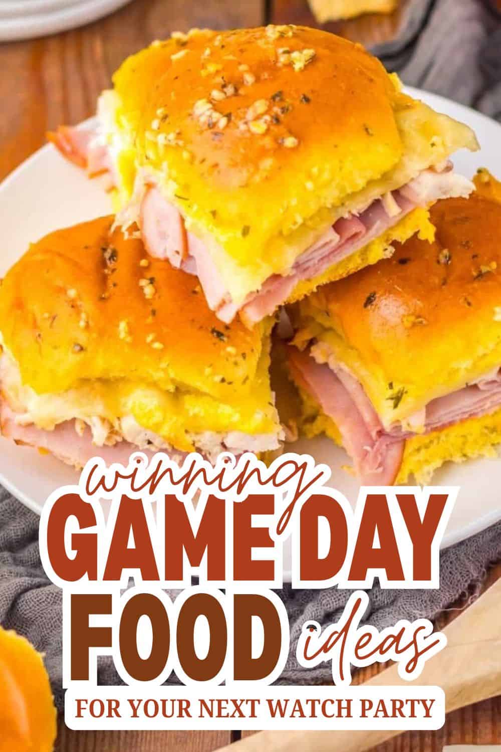 Delicious ham and cheese sliders with golden bread and herbs for game day.