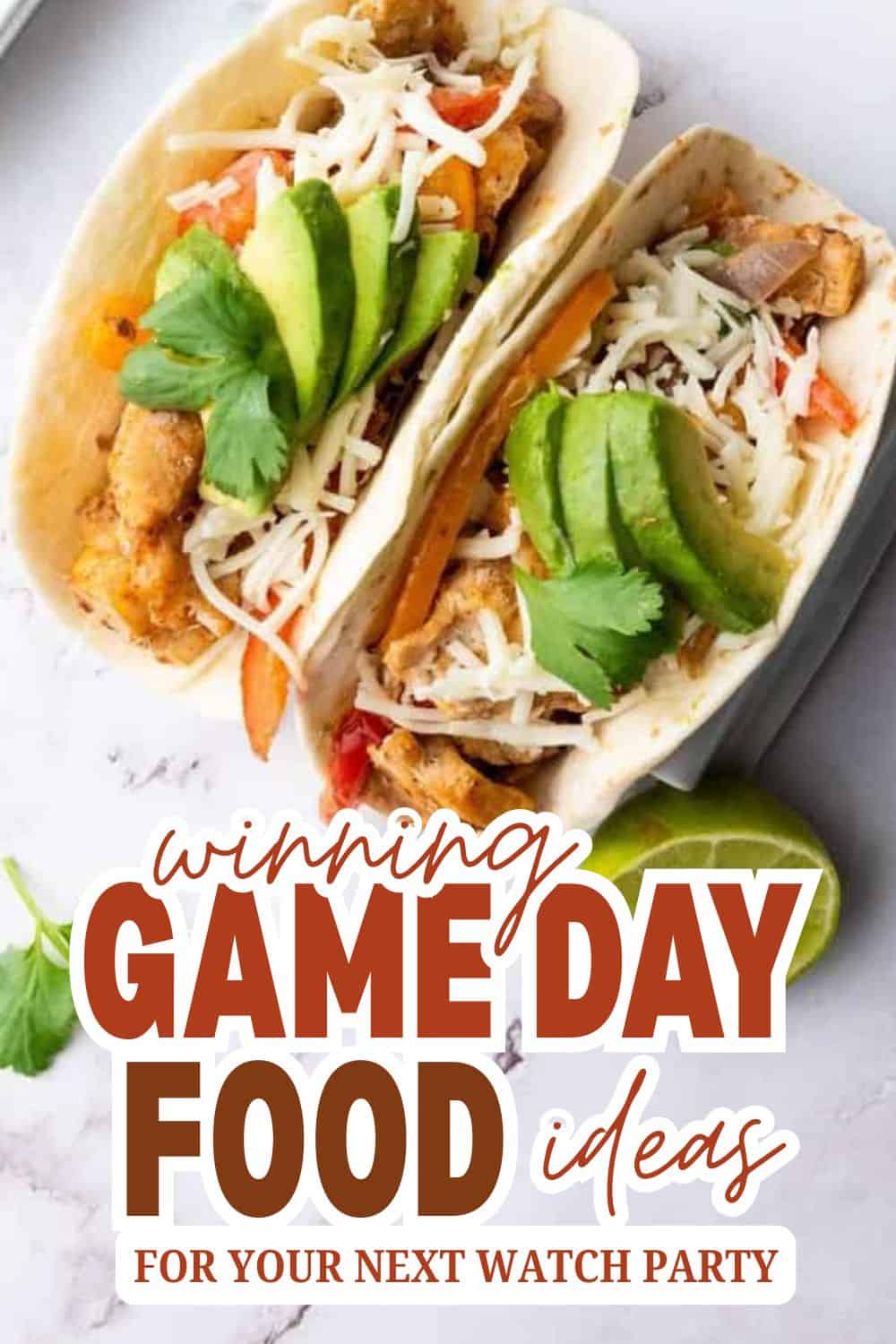 Two tacos filled with fried chicken, cheese, and fresh vegetables for game day.