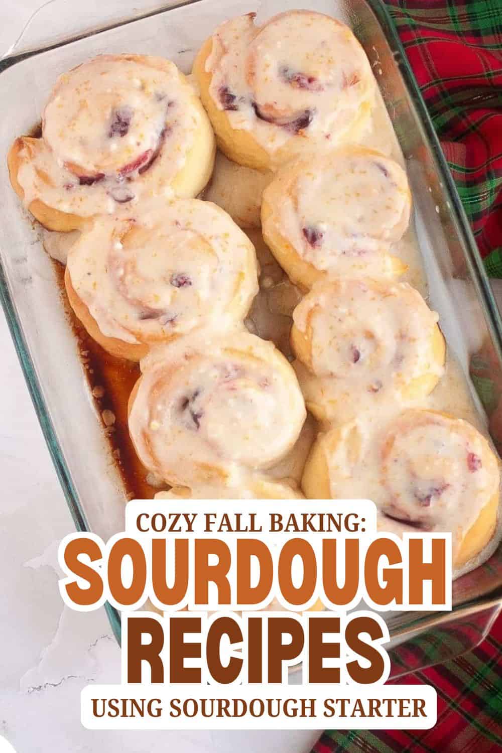 Freshly baked sourdough rolls with creamy topping in a glass dish.