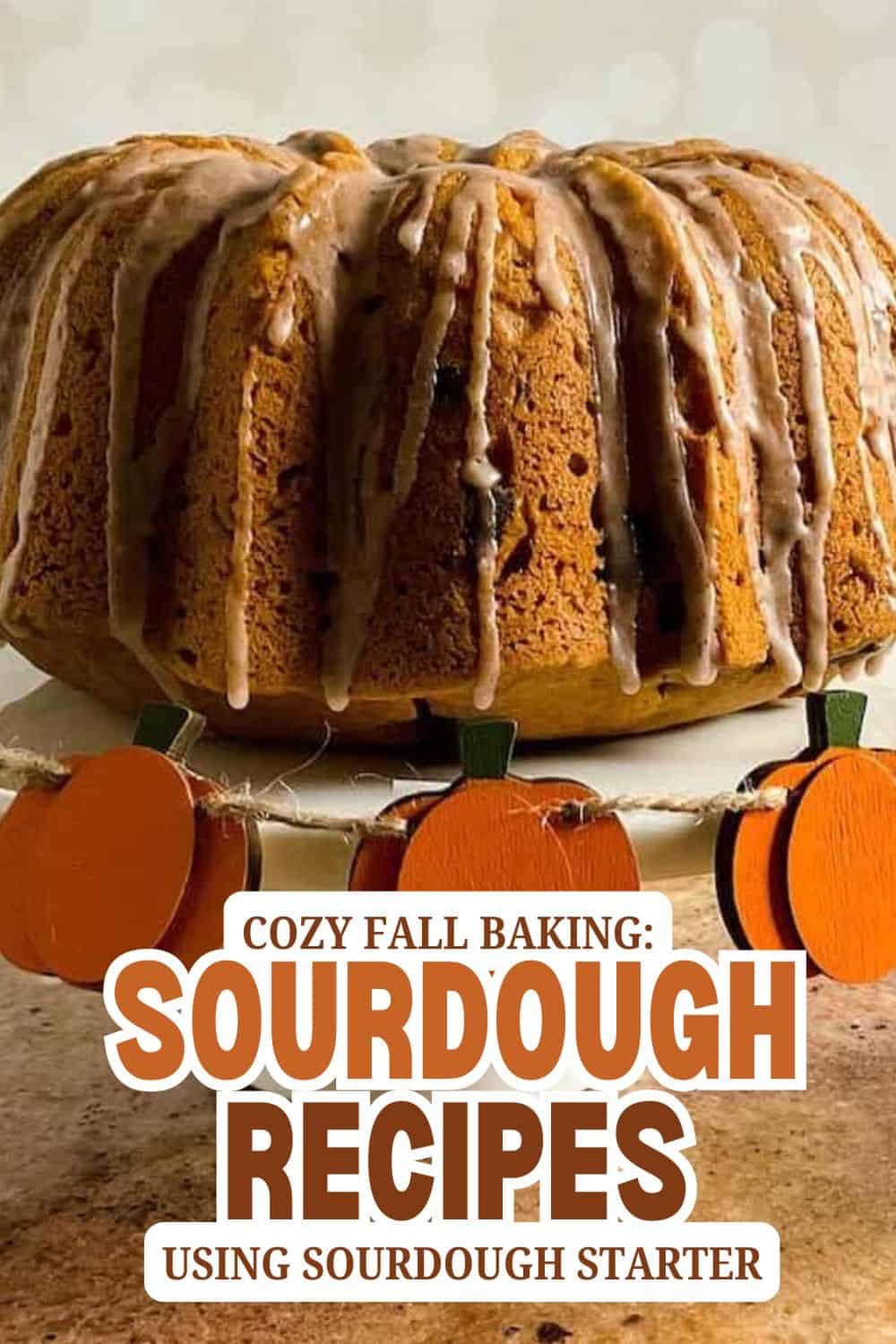 Pumpkin-shaped decorations with a sourdough bread loaf on a rustic surface.
