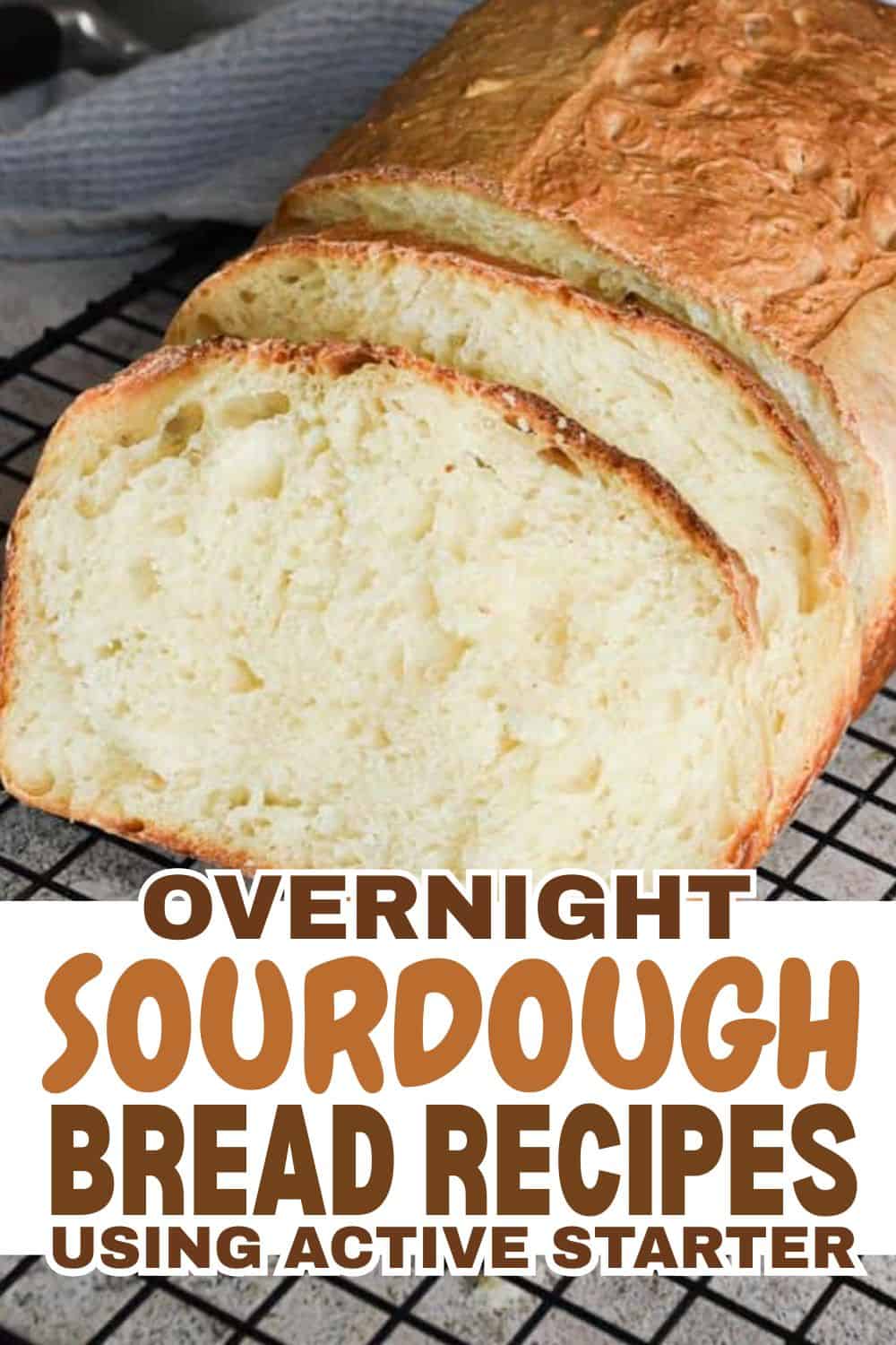 Freshly baked sourdough bread loaf with slices on cooling rack.