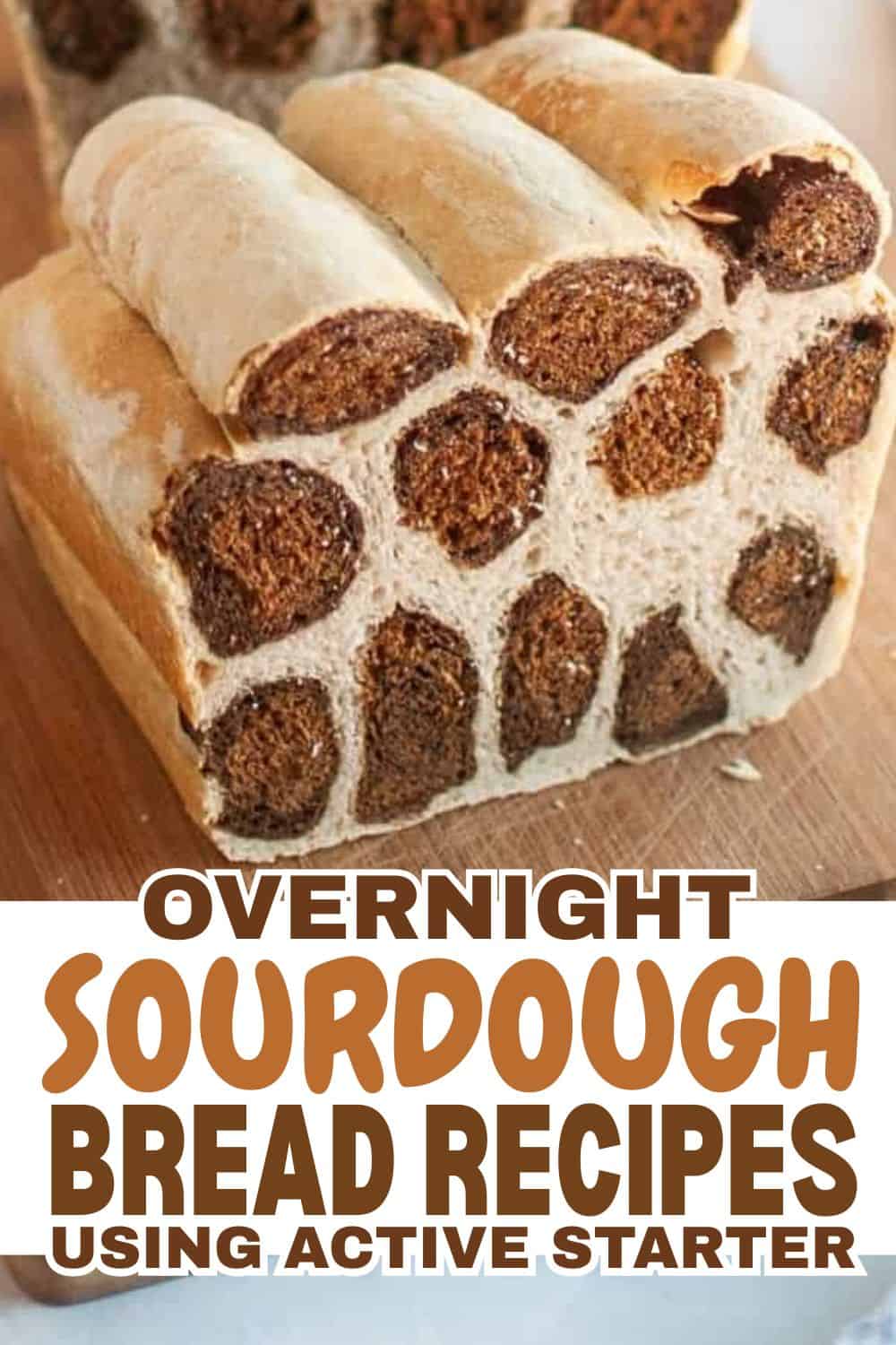 Freshly baked sourdough bread with multiple rolls on a wooden surface.