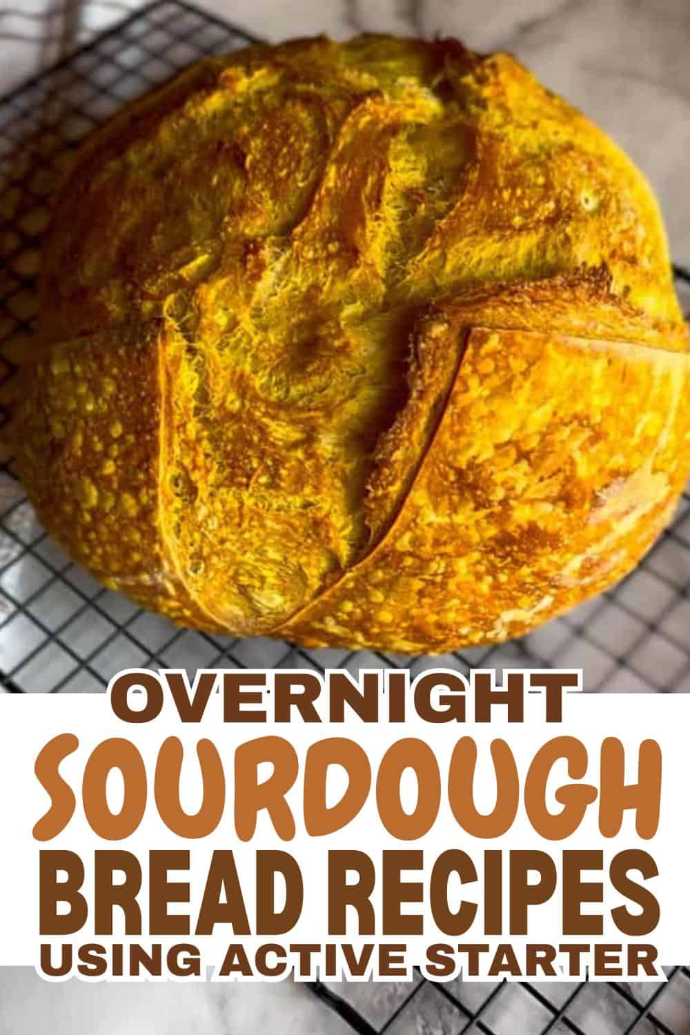 Freshly baked sourdough bread with a golden crust on a cooling rack.