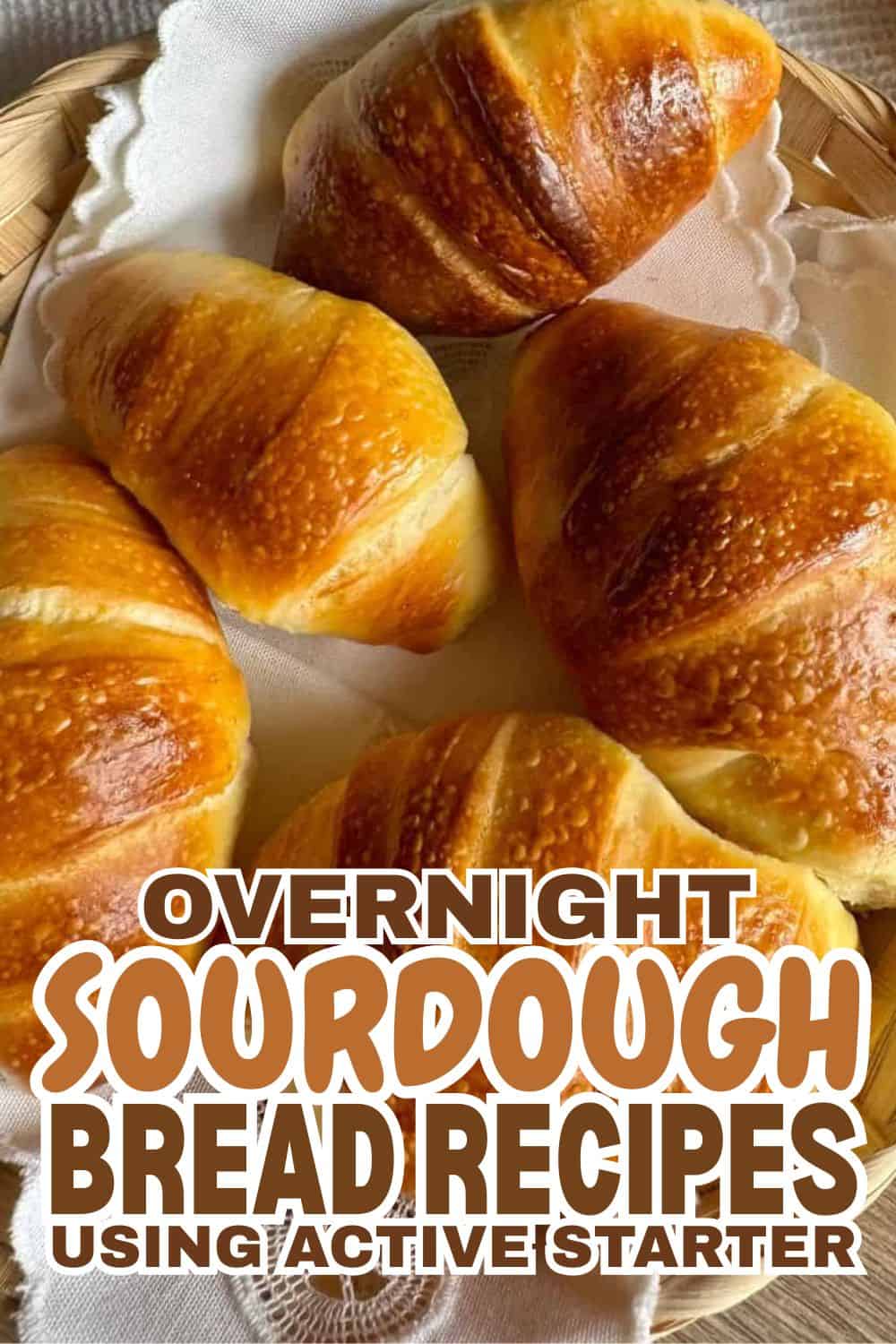Freshly baked sourdough croissants on a basket with parchment paper.