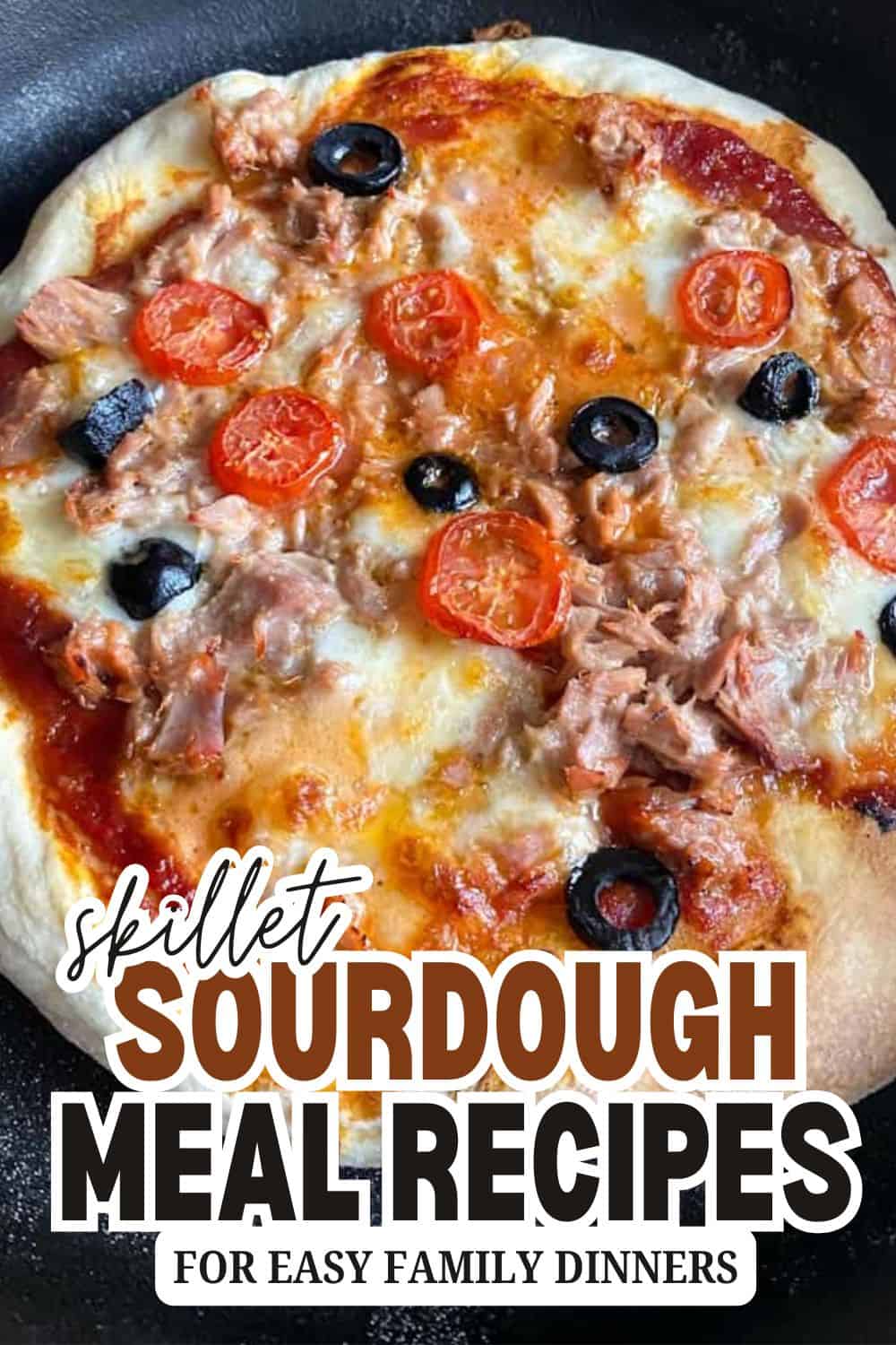 Close-up of sourdough pizza with cherry tomatoes, black olives, and tuna.