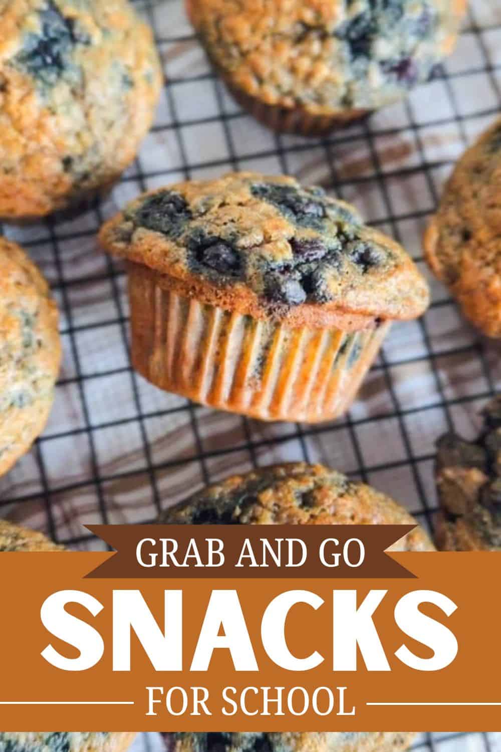 Freshly baked blueberry muffins on a cooling rack with blueberries inside.