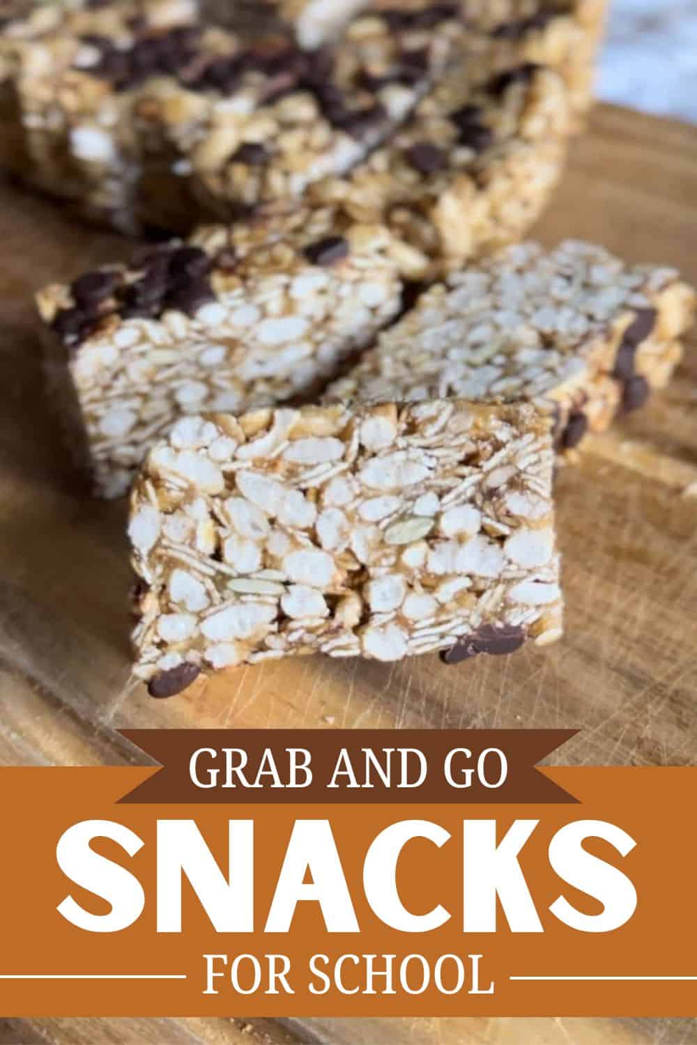 Homemade oat and nut snack bars with chocolate chips on a wooden surface.