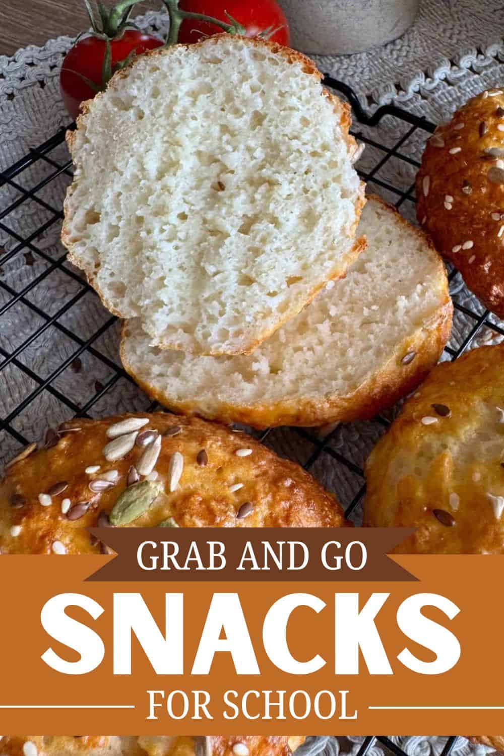 Close-up of sliced homemade bread on cooling rack with bread rolls nearby.