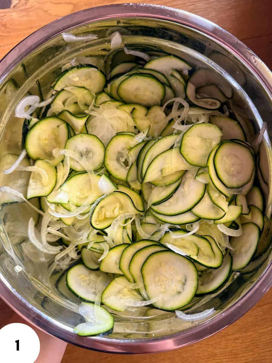 Thinly sliced zucchini and onions in a mixing bowl for bread dough.