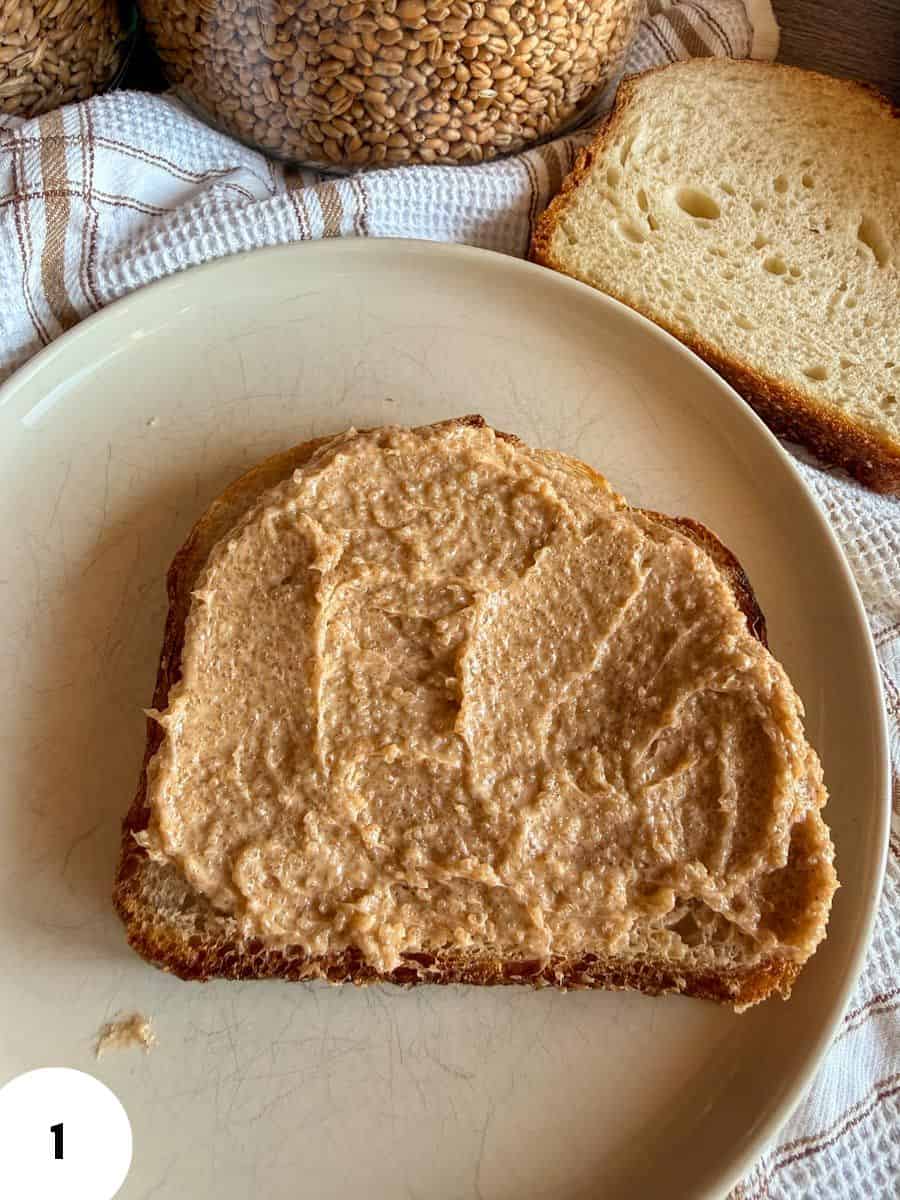 Slice of bread with spread on top, ready for baking or serving.