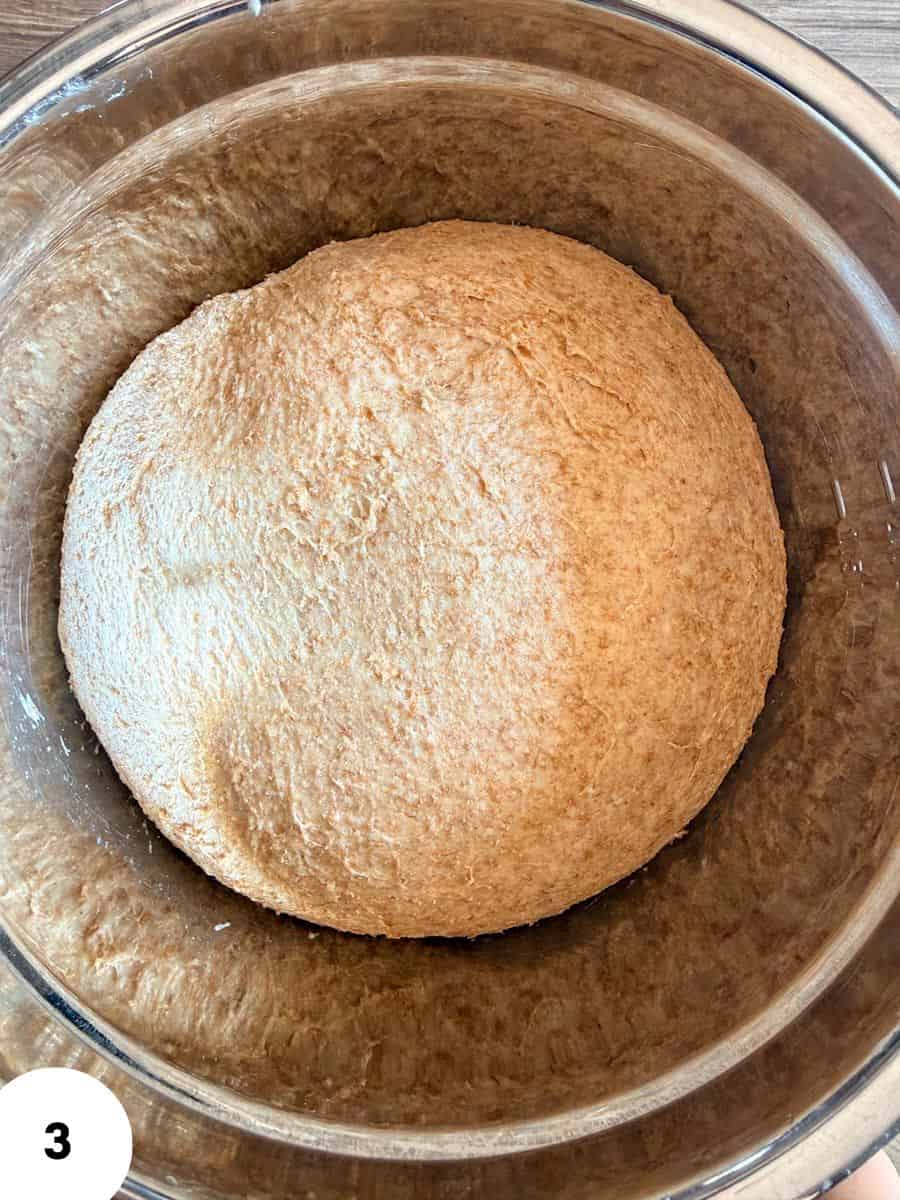 Ball of sourdough bread dough in a glass bowl for baking.