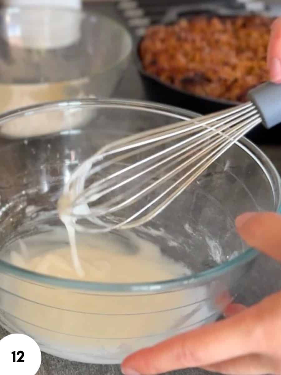 Person whisking dough in a glass bowl for bread baking.