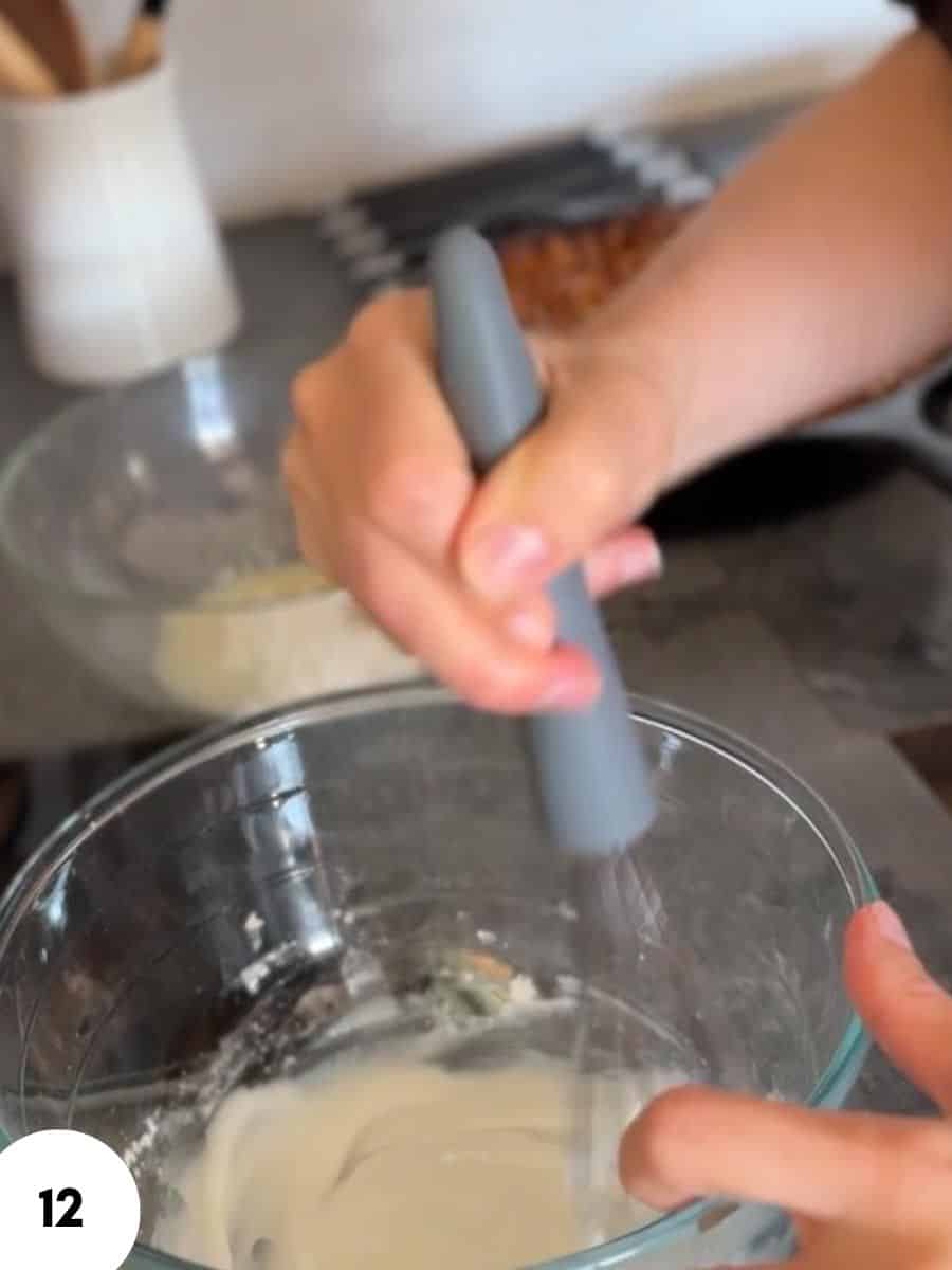 Person performing stretch and fold bread dough technique in a glass bowl.