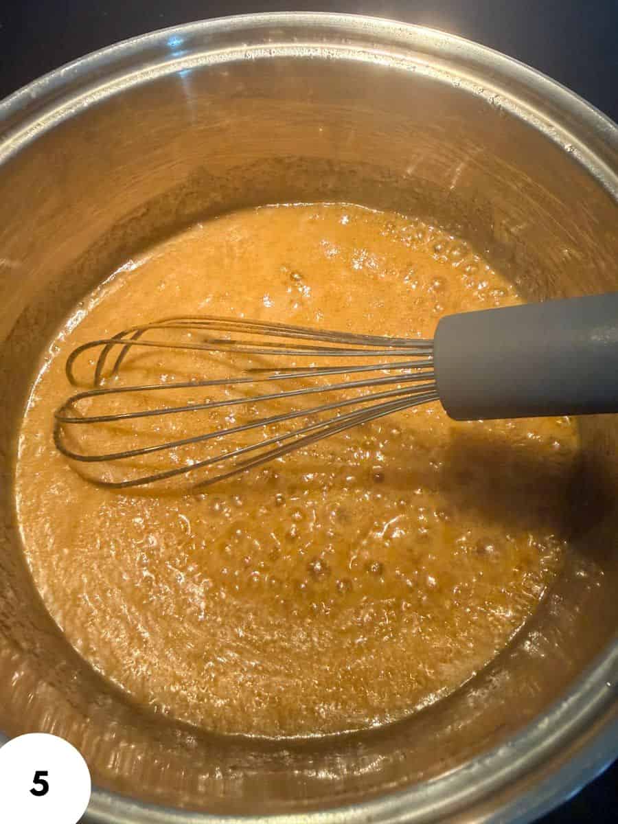Melting caramel mixture in a pot with a whisk for sourdough focaccia.