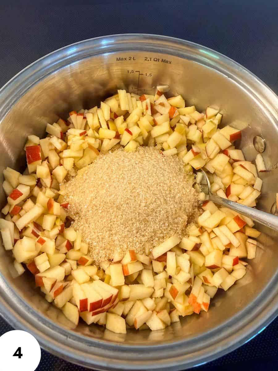Chopped apples with sugar in a mixing bowl for baking or cooking.