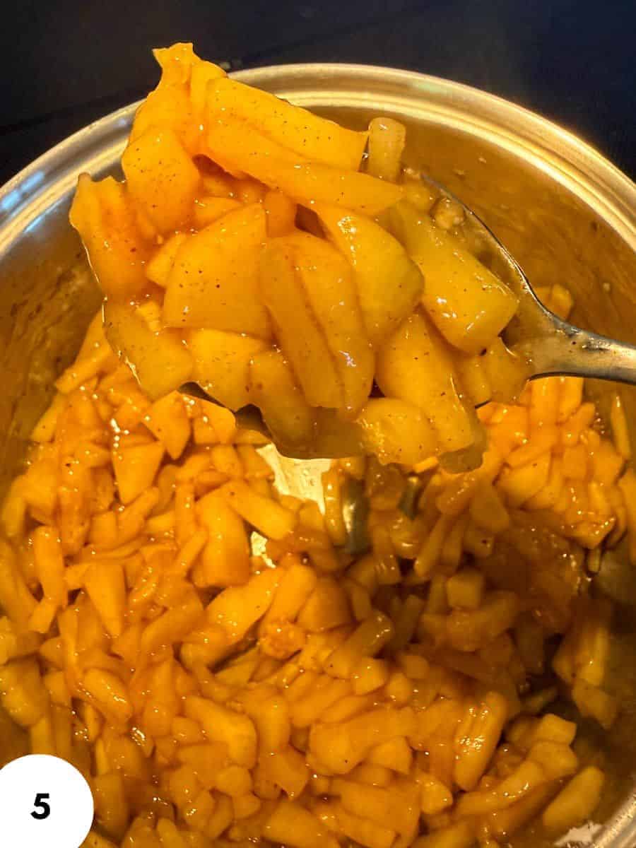 Close-up of diced and sliced pickled fruit in a jar.