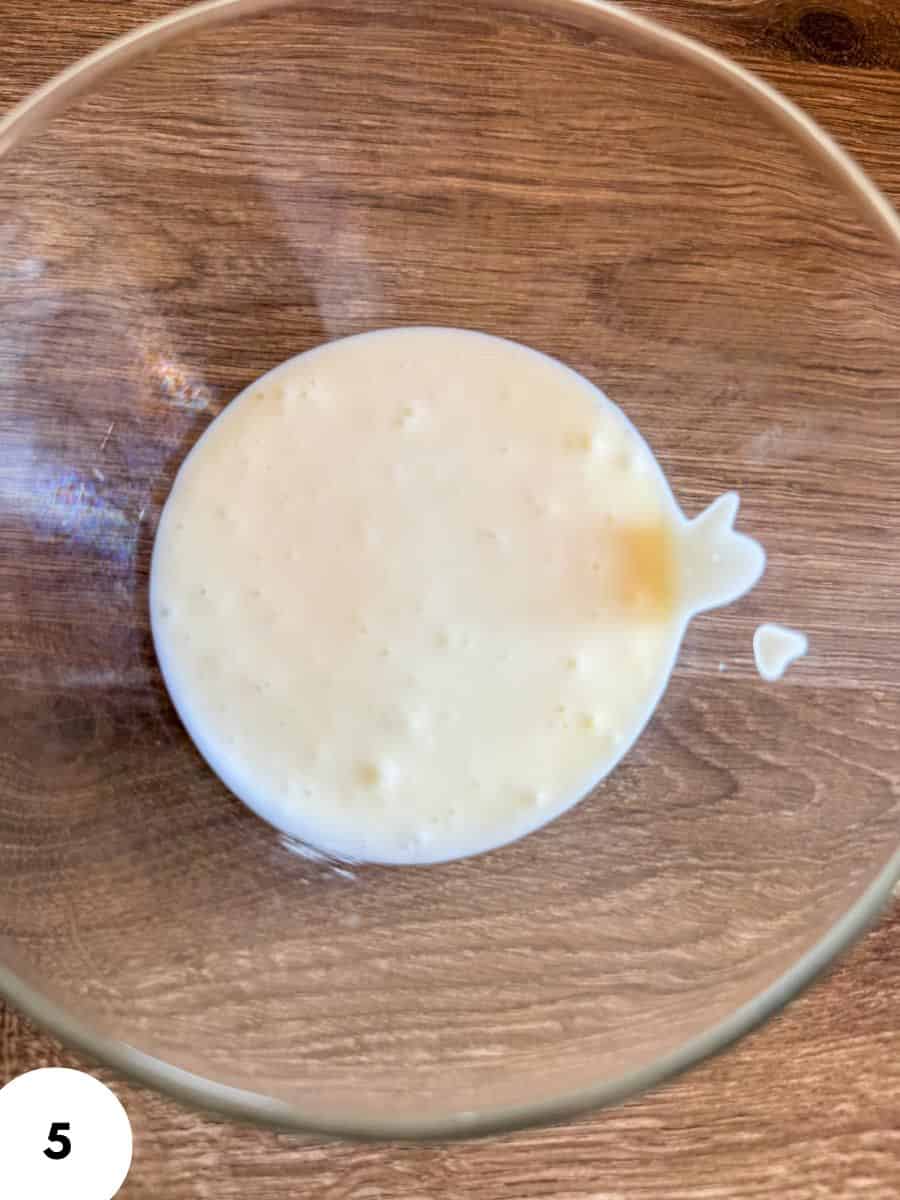 Creamy bread dough in a glass bowl ready for proofing.