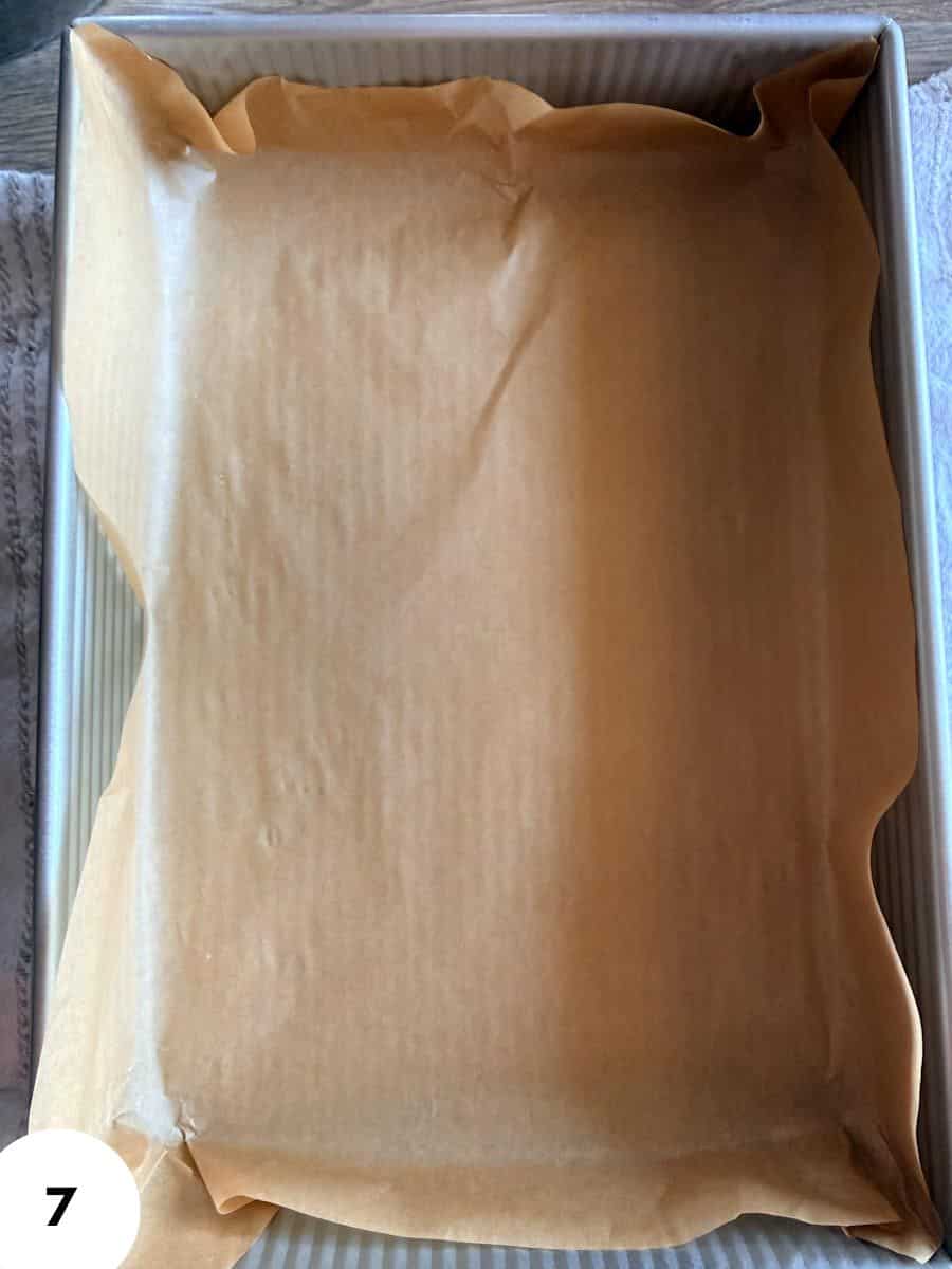 Empty baking tray lined with parchment paper for bread or pastry proofing.