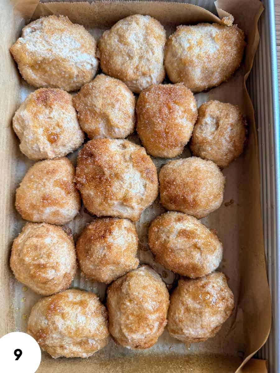 Golden bread rolls with a crispy crust in a baking tray.