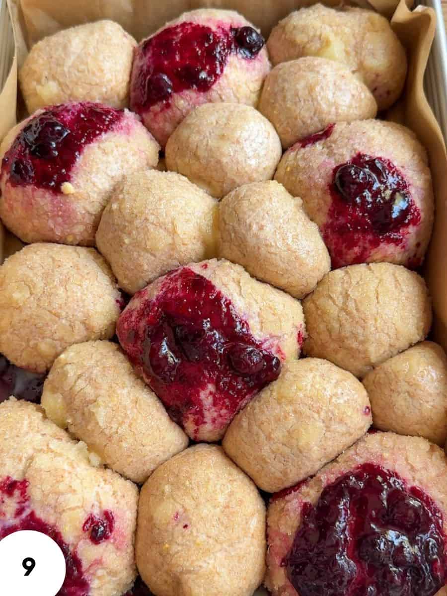 Close-up of cookies with berry topping and golden crust.